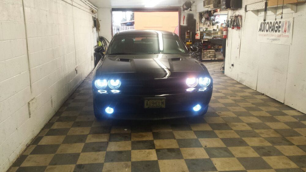 A black dodge challenger is parked in a garage.