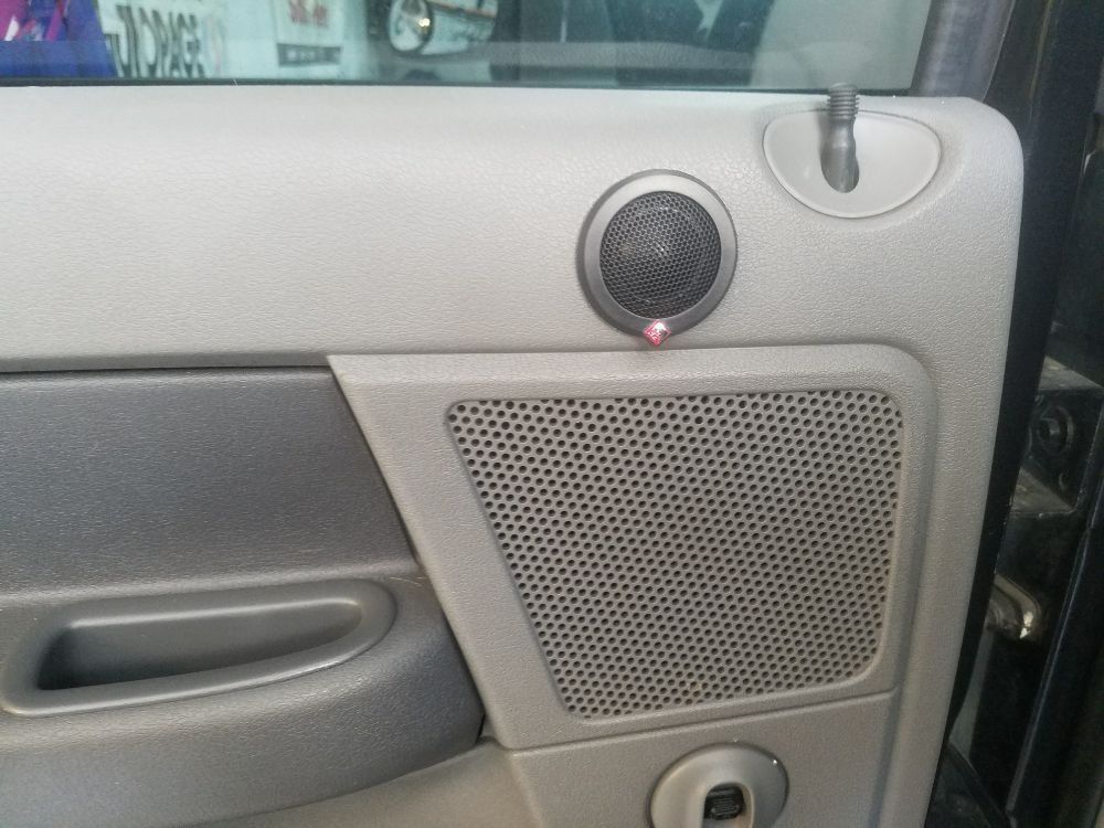 A close up of a car door with a speaker on it
