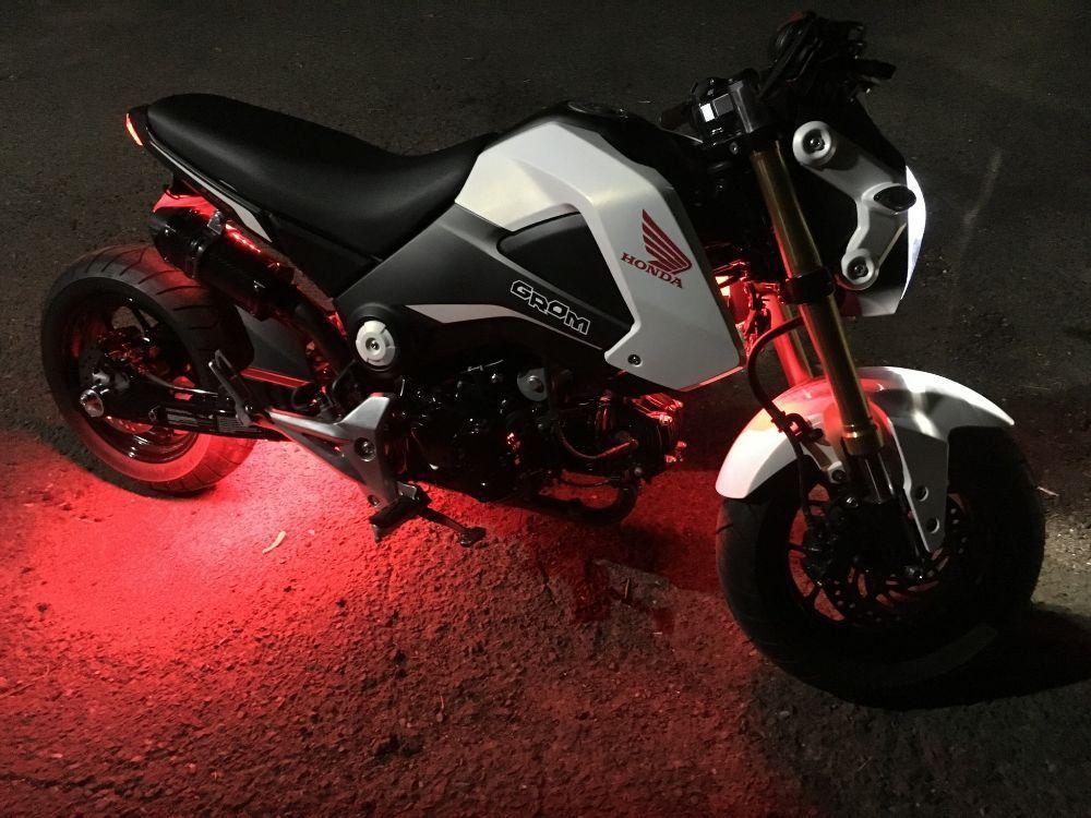 A motorcycle with red lights on it is parked on the ground.