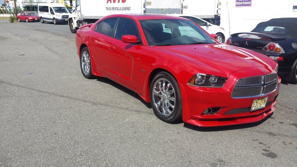 A red dodge charger is parked in a parking lot