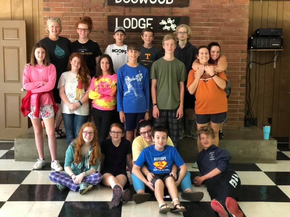 Group of teenagers in front of a brick wall with 