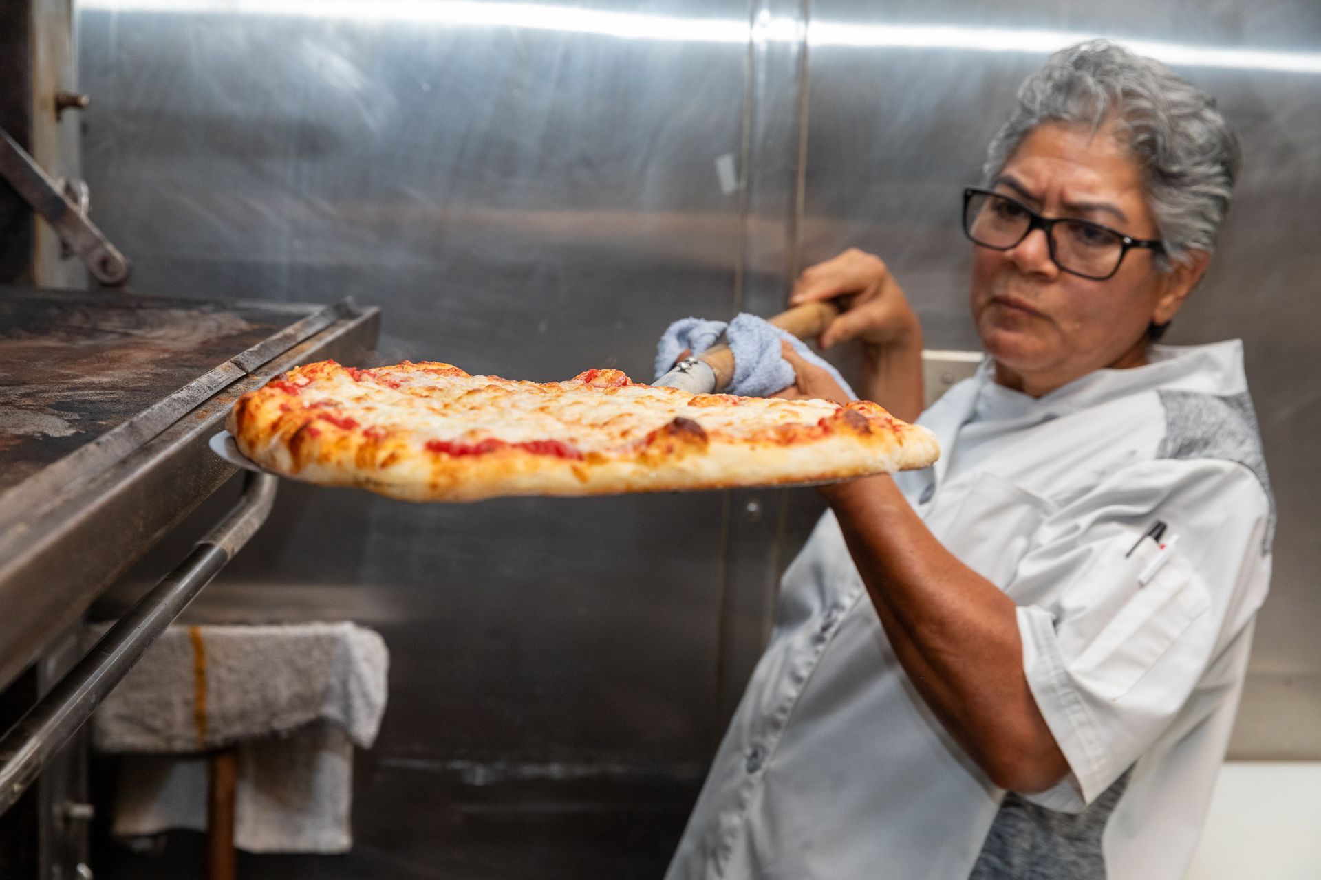A woman is holding a slice of pizza in her hand