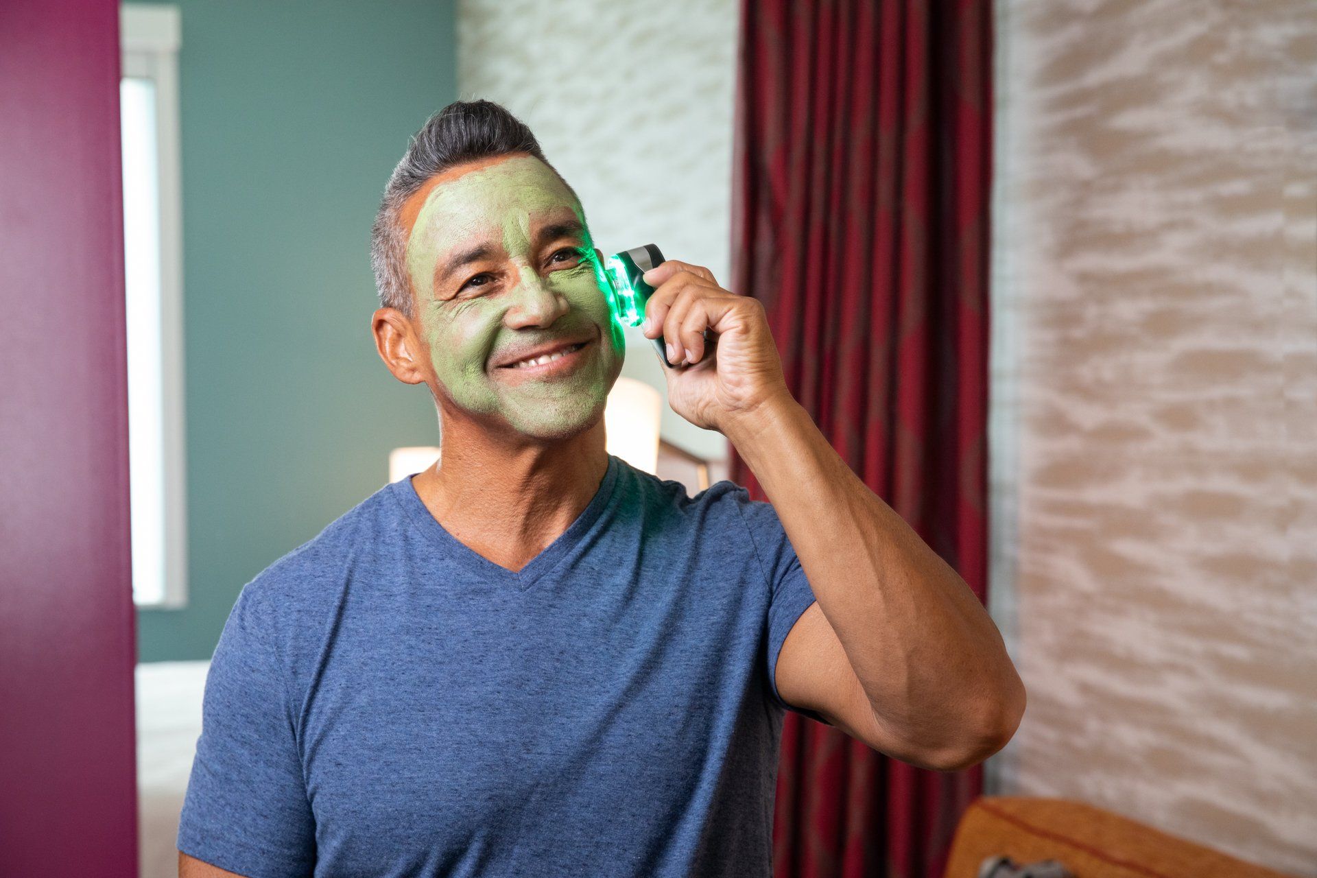 A man with a green mask on his face is smiling