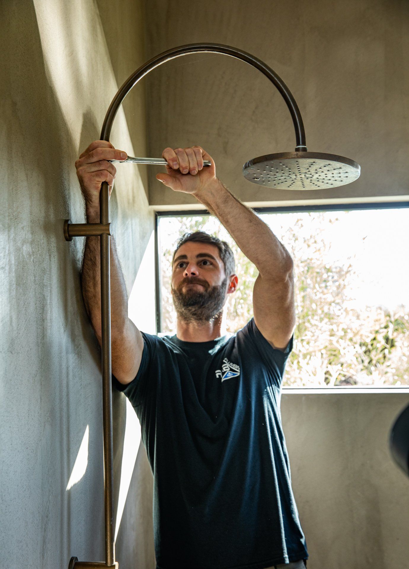 A man is fixing a shower head with a screwdriver