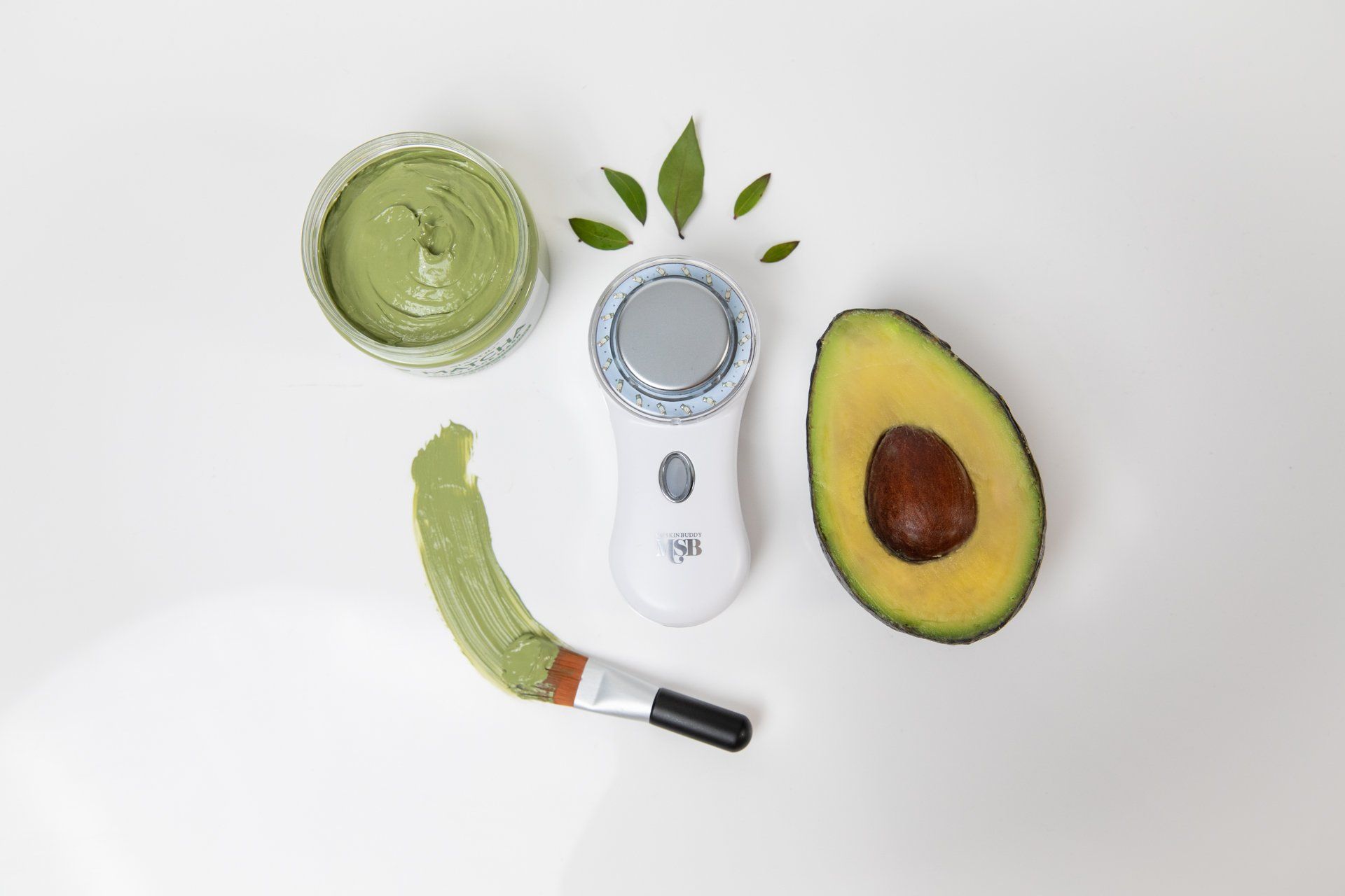 An avocado next to a device that looks like a face mask