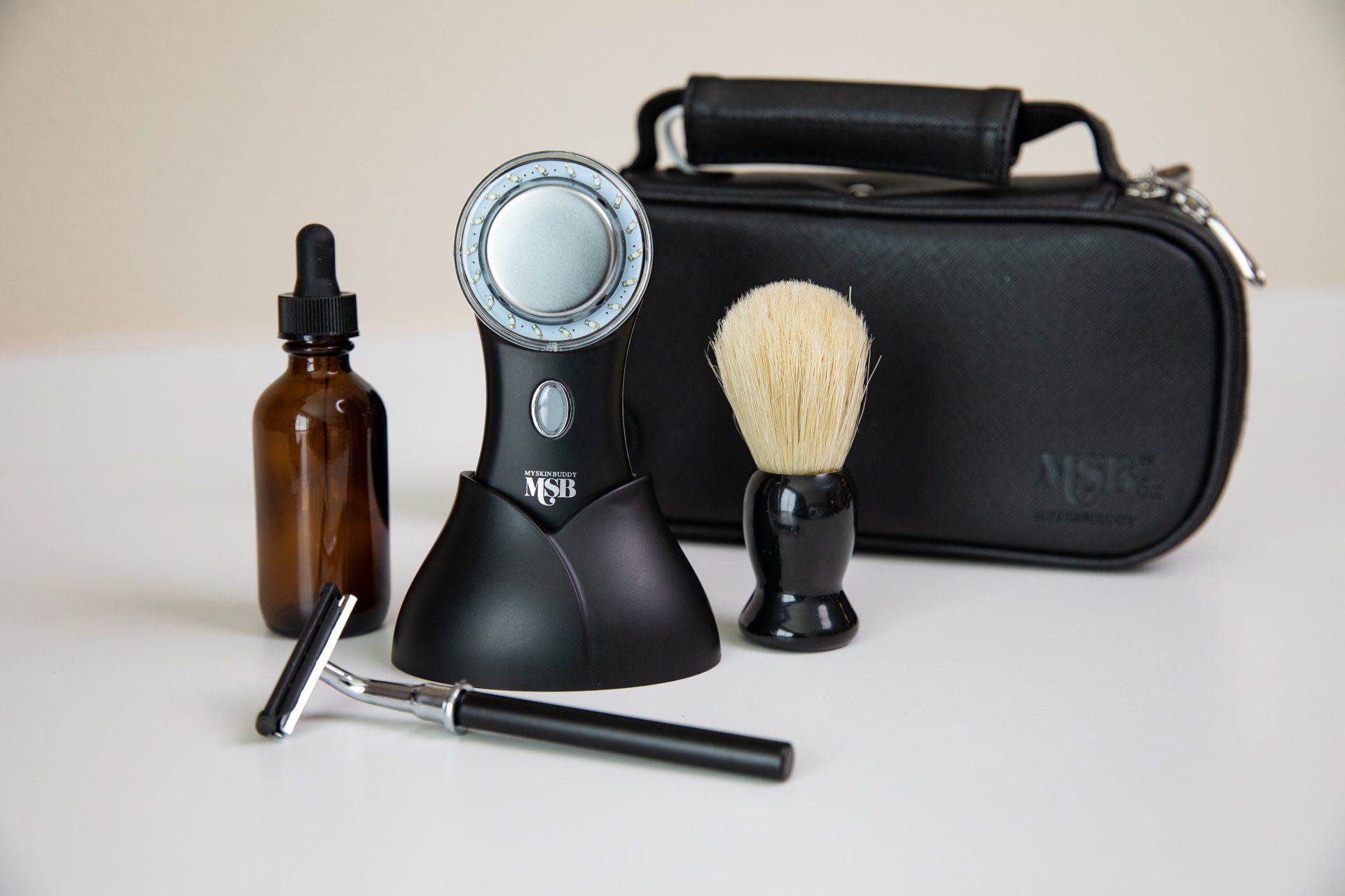 A shaving kit with a razor brush and a bottle of oil