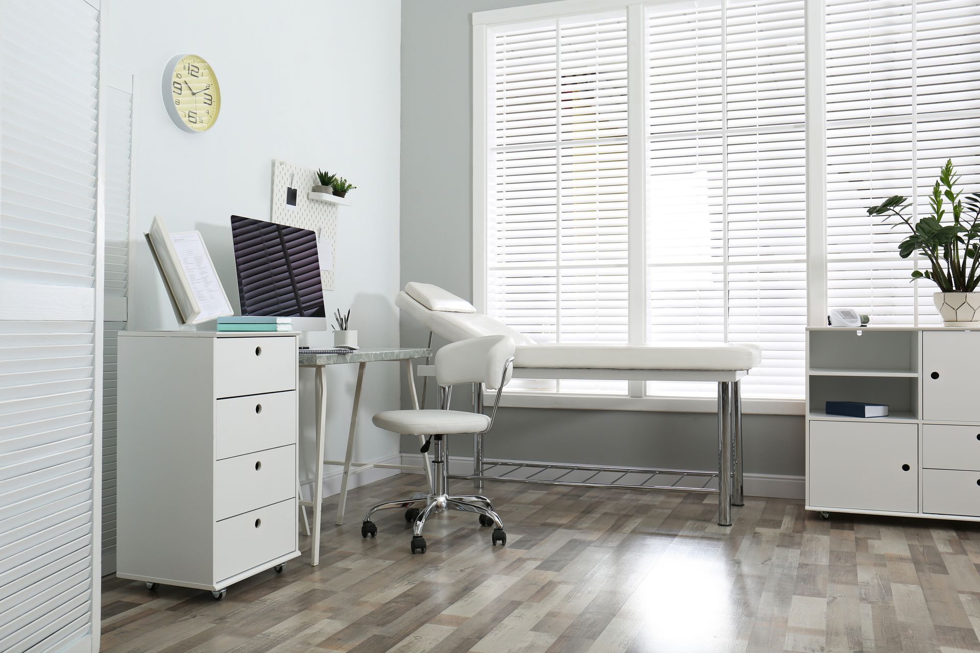 A room with a desk , chair , and a clock on the wall.