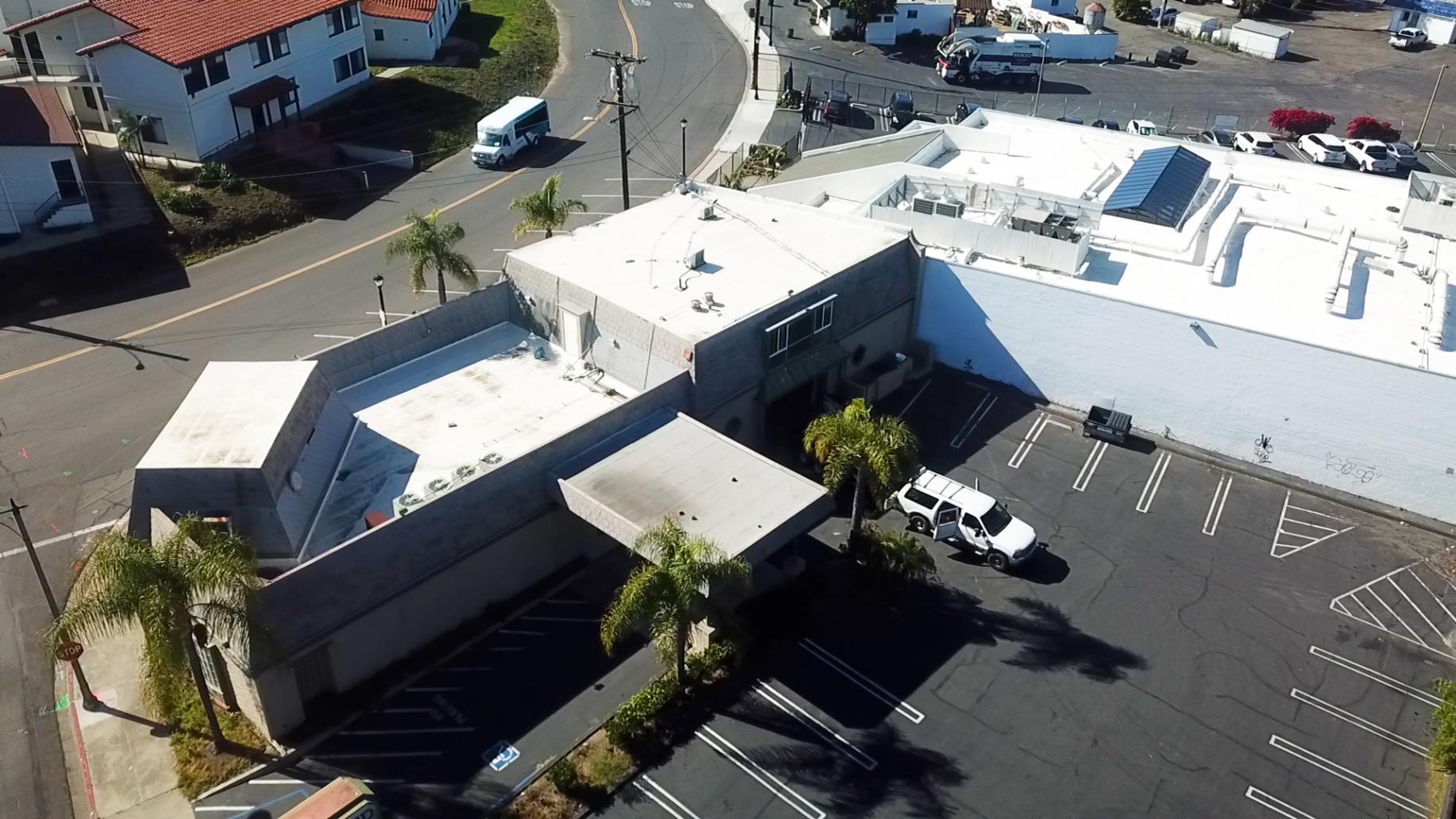 An aerial view of a building with a white roof