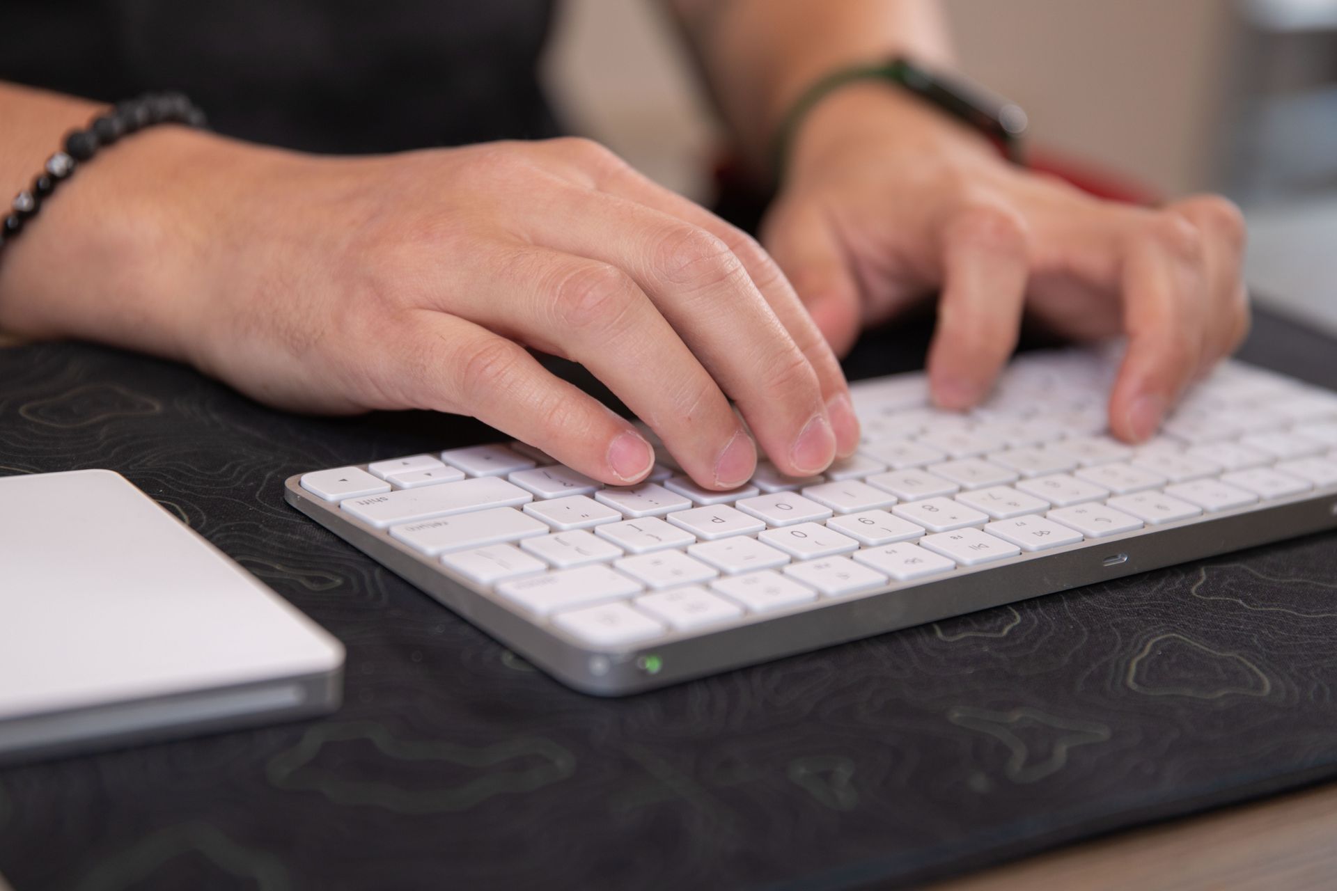 A person is typing on a white keyboard