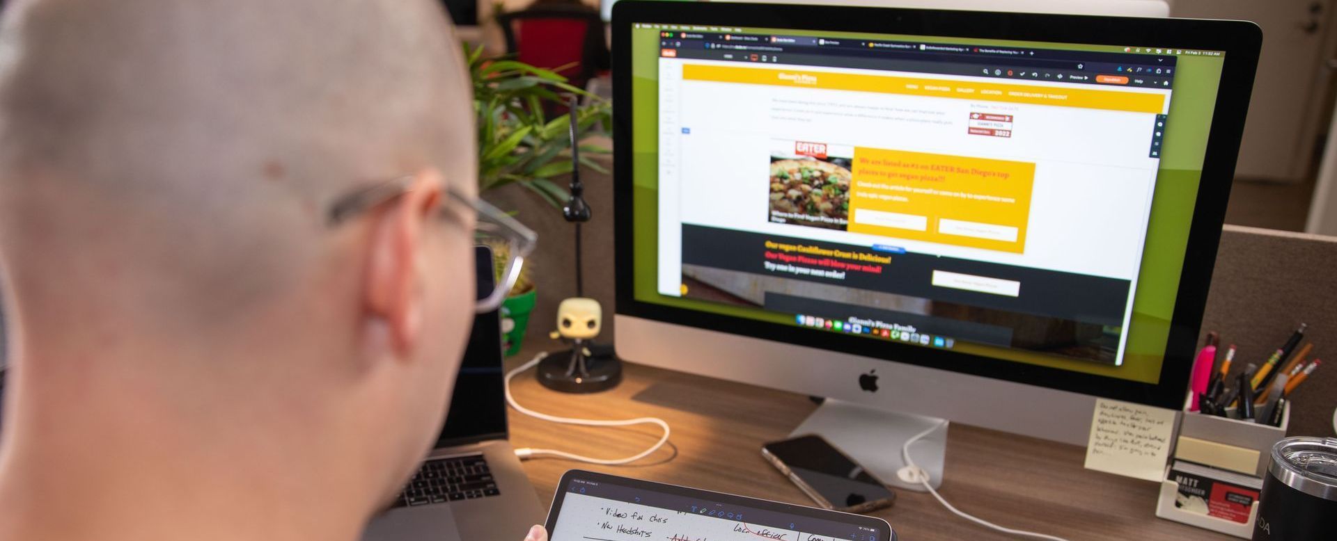 A man wearing glasses is looking at a computer screen