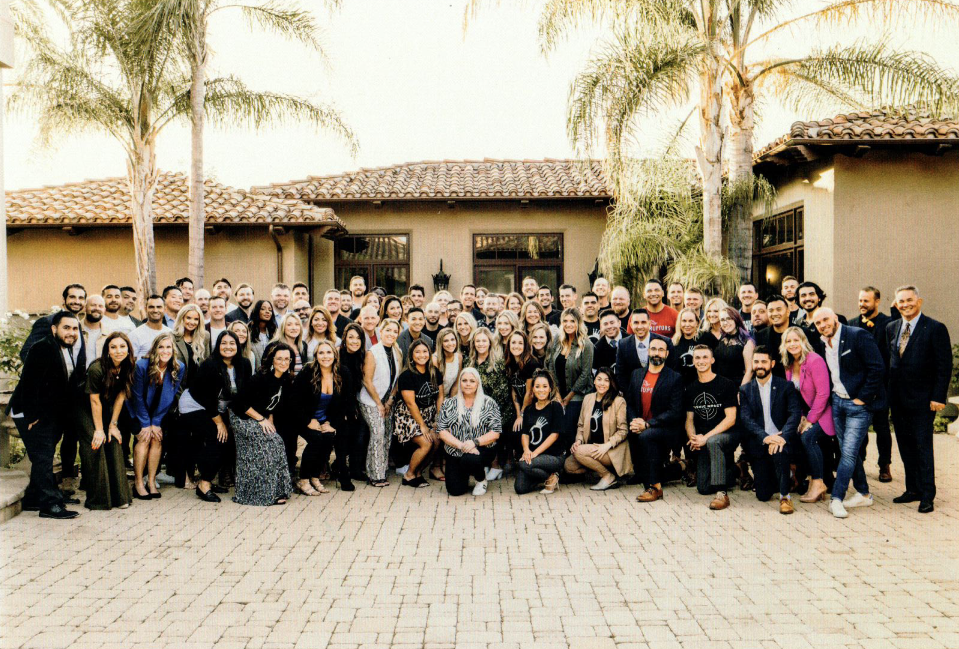 A large group of people are posing for a picture in front of a building