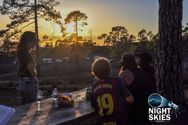 Guests relaxing at a picnic table among Tenerife’s pine trees at sunset