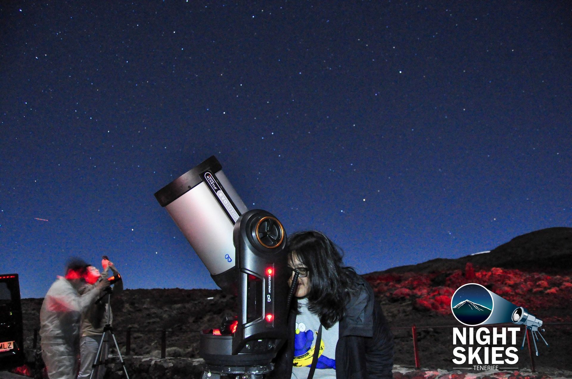 Guest observing the night sky through a telescope with Night Skies Tenerife