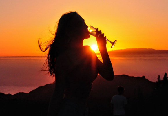 Woman enjoying Cava at sunset in Teide National Park, Tenerife