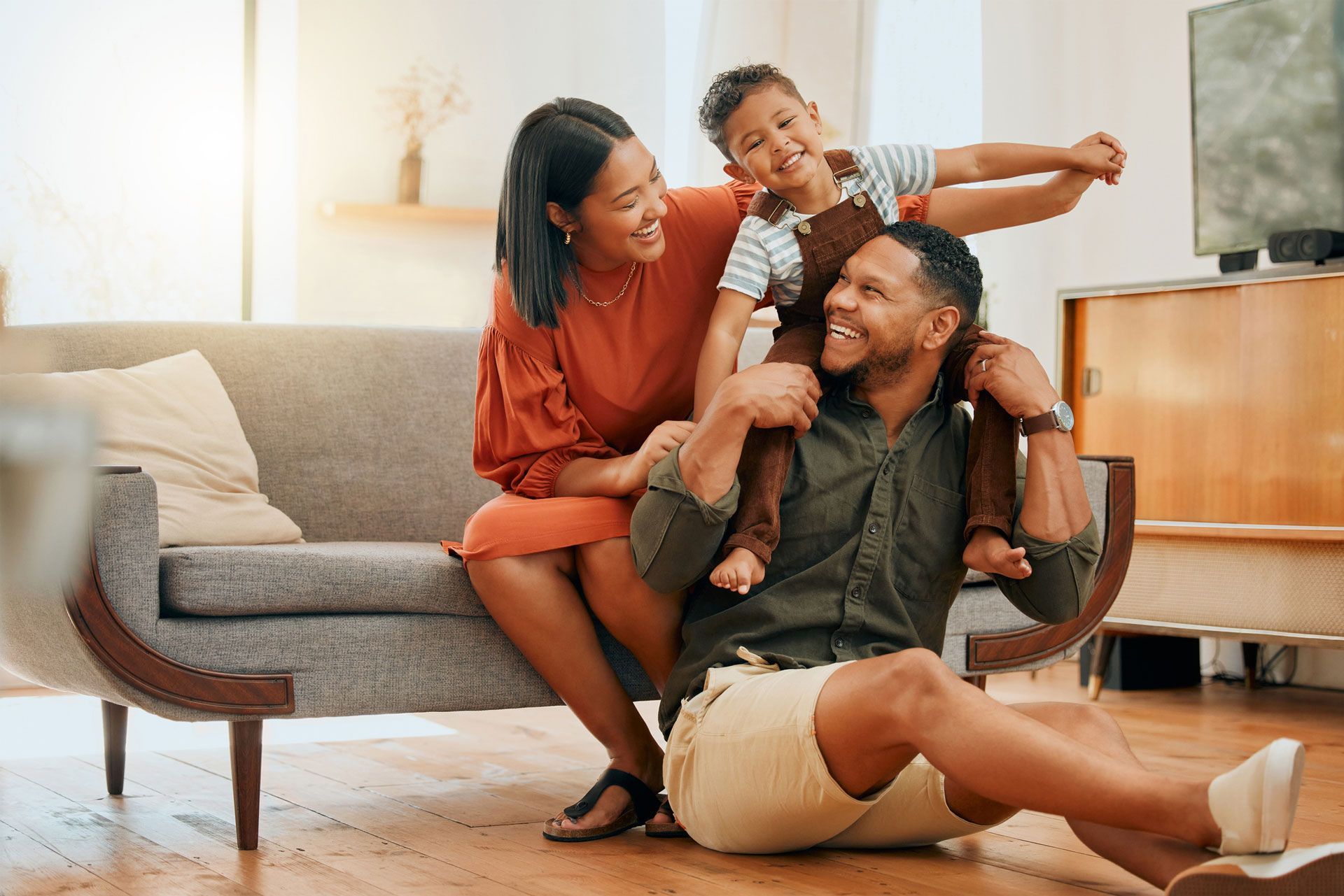 A family is sitting on a couch in a living room