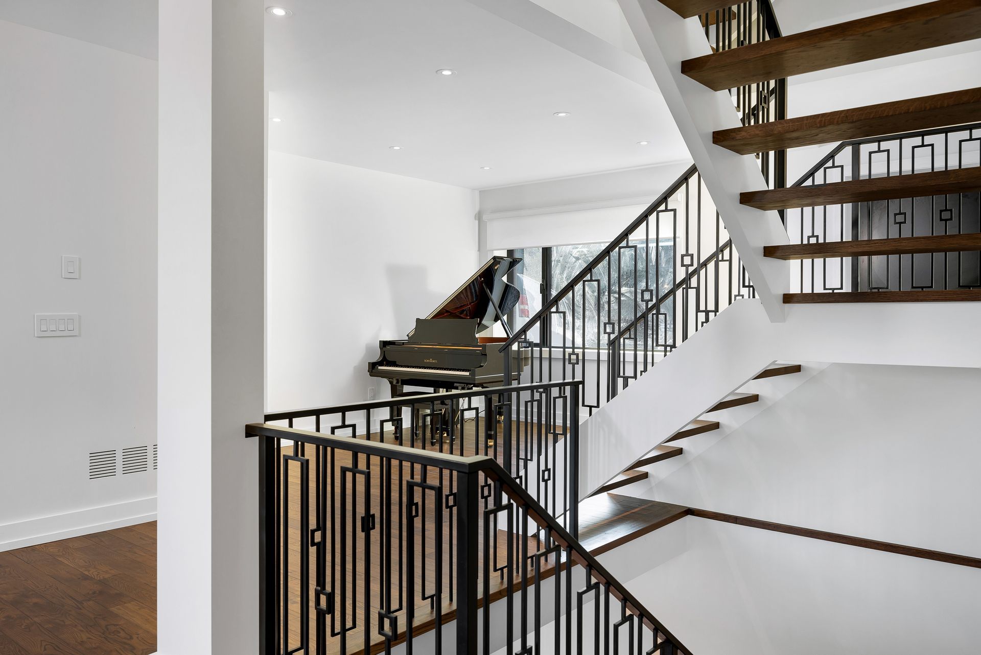 Bright staircase with black railings and white walls in a modern home interior