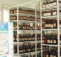 Estantes llenos de botellas y frascos en una tienda o despensa.