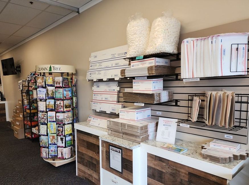 Retail showroom with stacked wallpaper rolls and sample books on display shelves