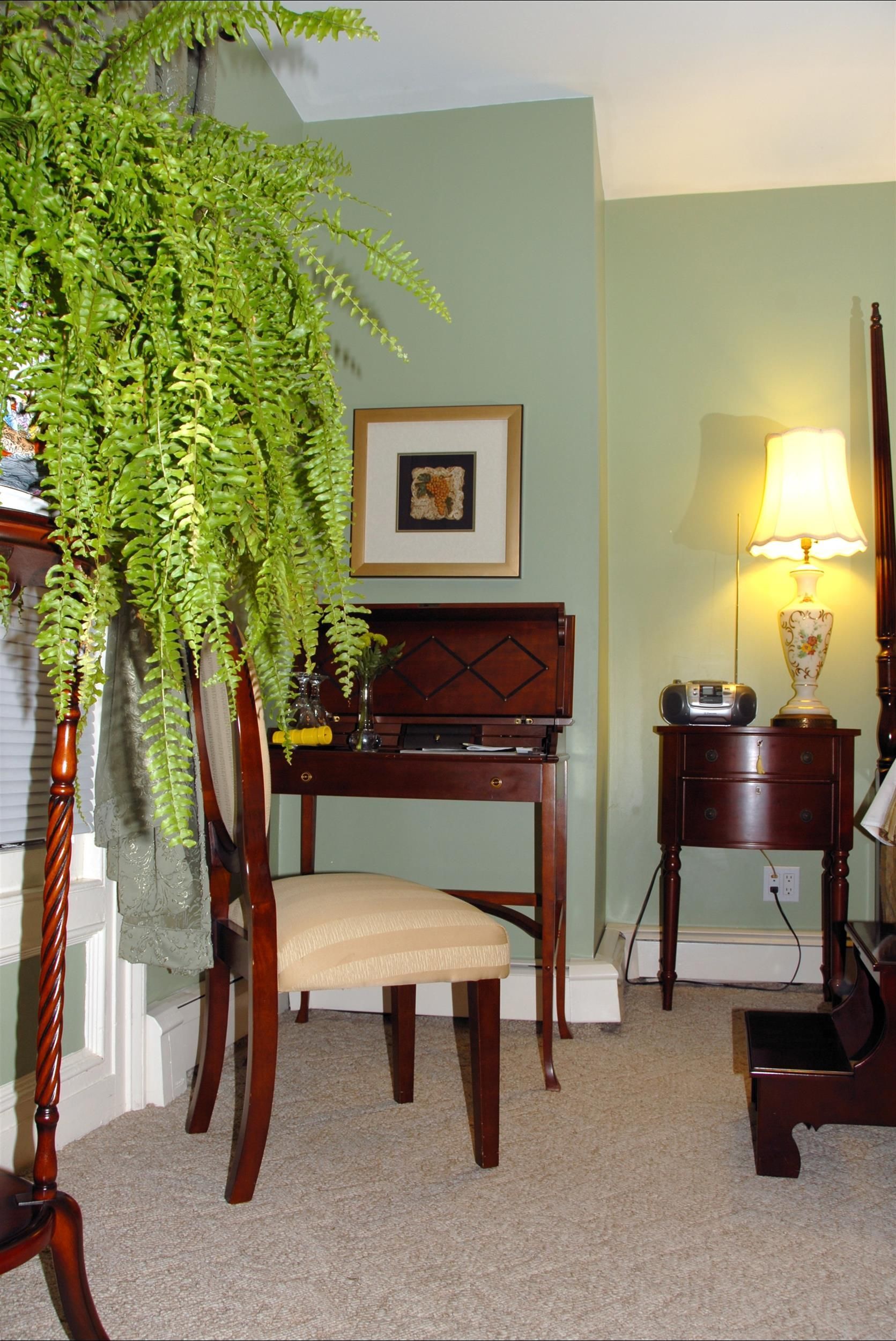 A living room with a desk chair and lamp