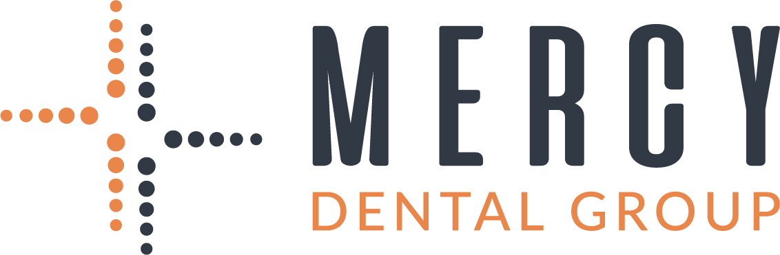 Mercy Dental Group logo with orange and navy cross icon and text