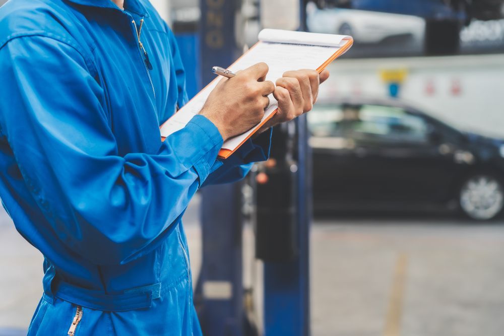 Mechanic writing in clip board - Specialist Mechanics in Cairns, QLD