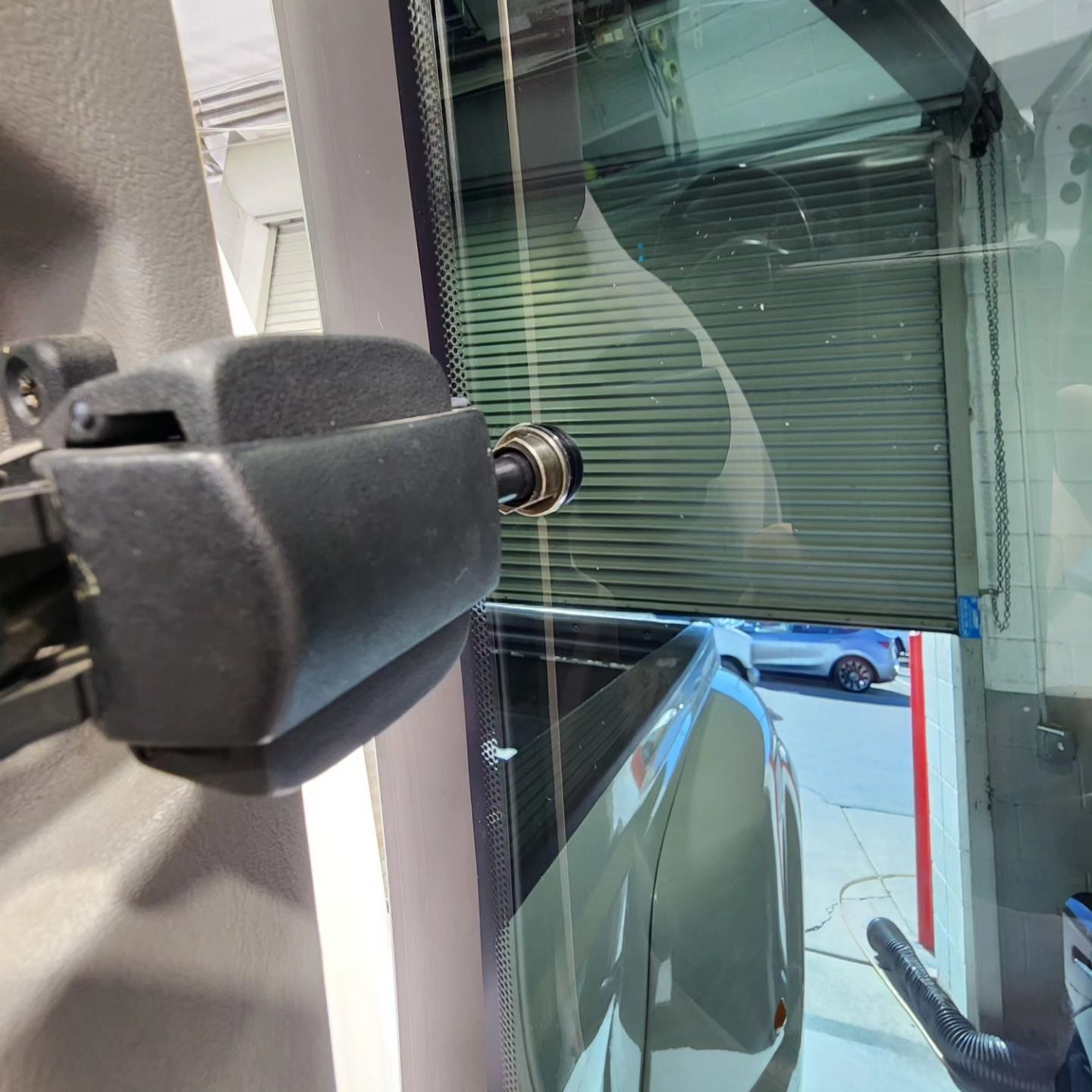 A car is parked in a garage with the door open.