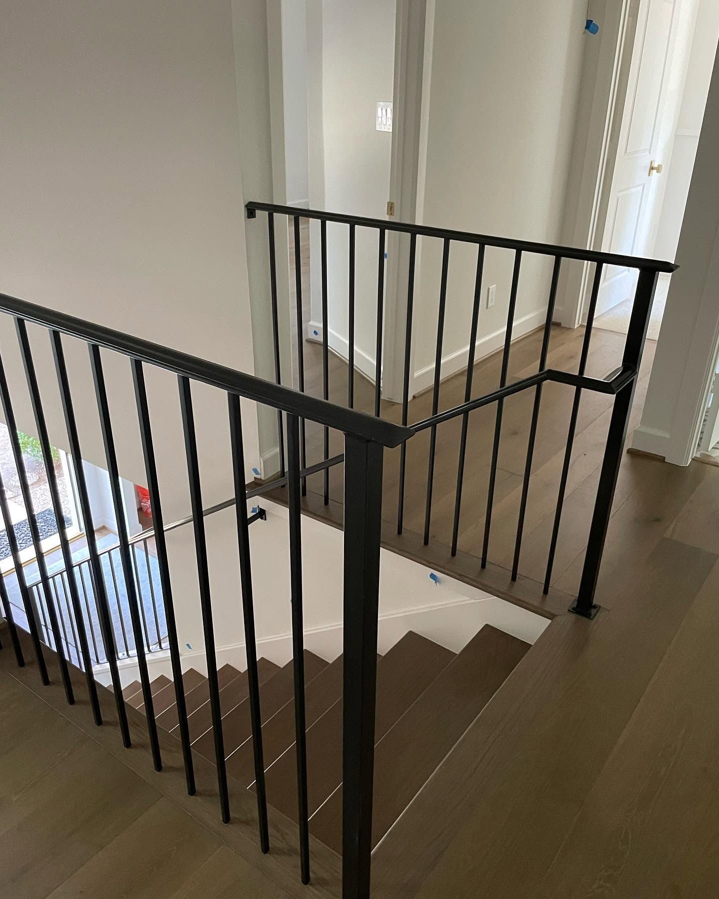 Stairwell with black metal railings and brown steps in a bright indoor hallway
