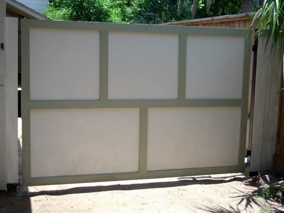 Closed beige gate with square panels in a driveway entrance