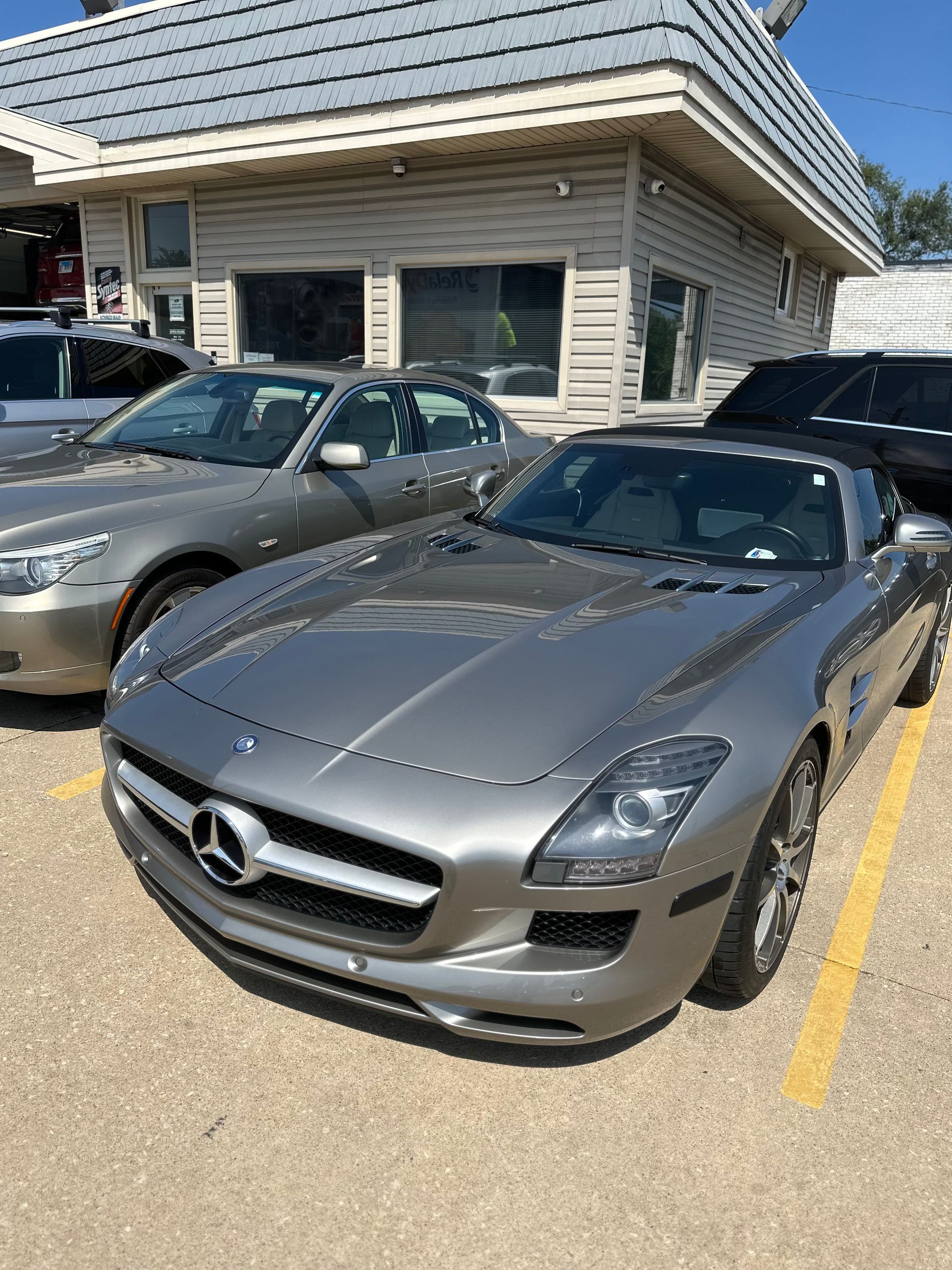 Gray Mercedes convertible parked in front of a building on a sunny day