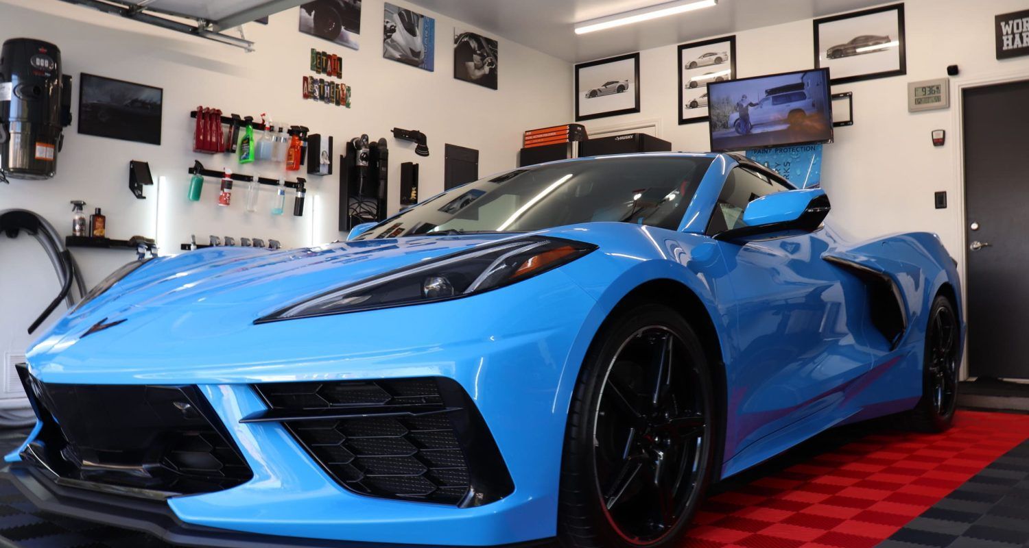 A blue sports car is parked in a garage.