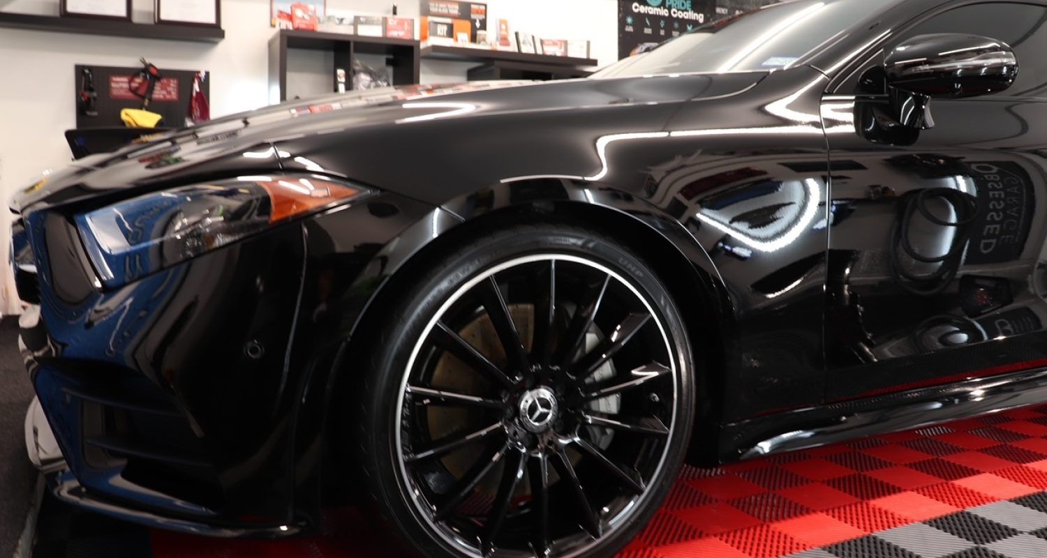 A black sports car is parked in a garage.