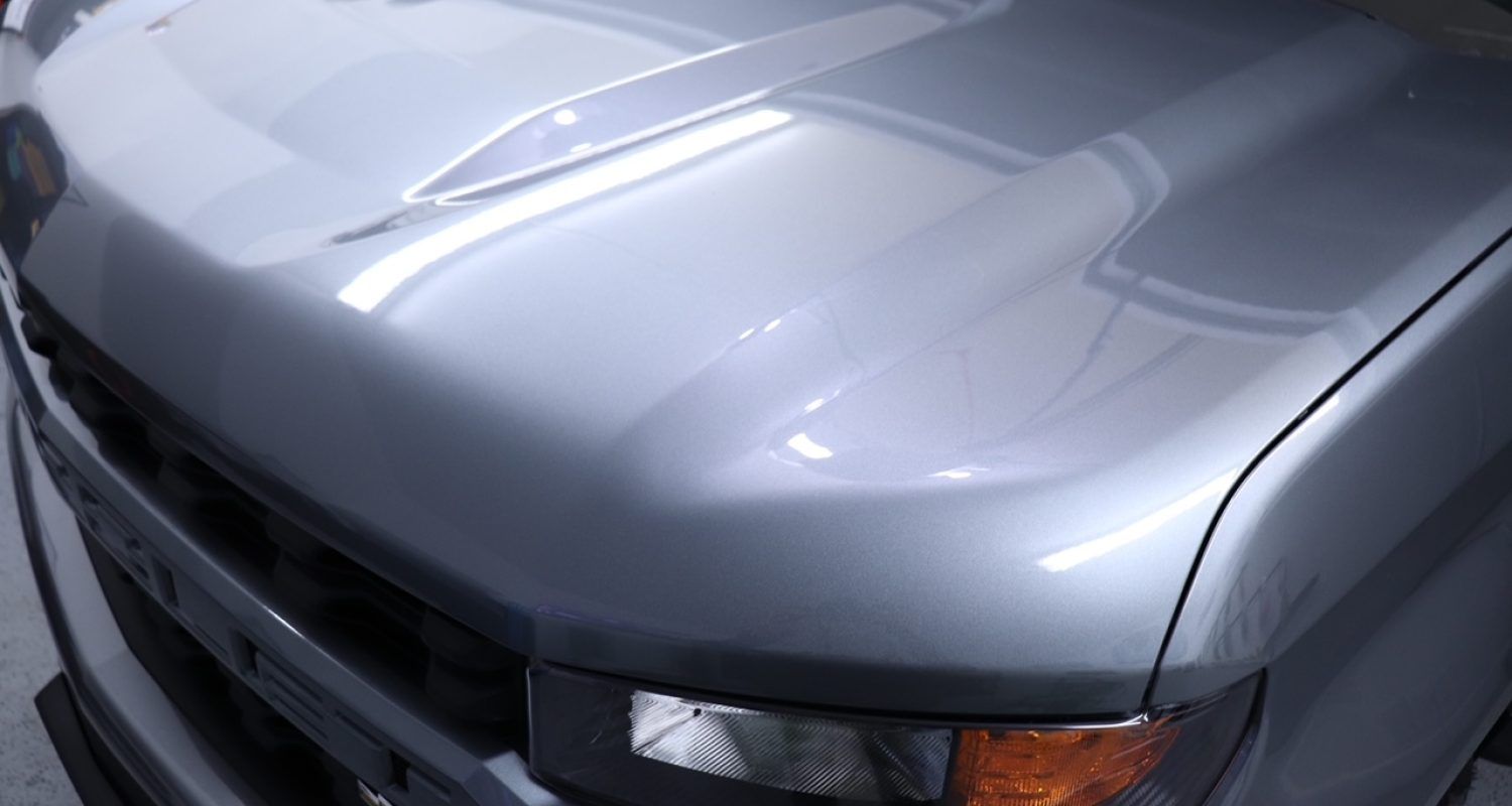 A close up of the hood of a silver car