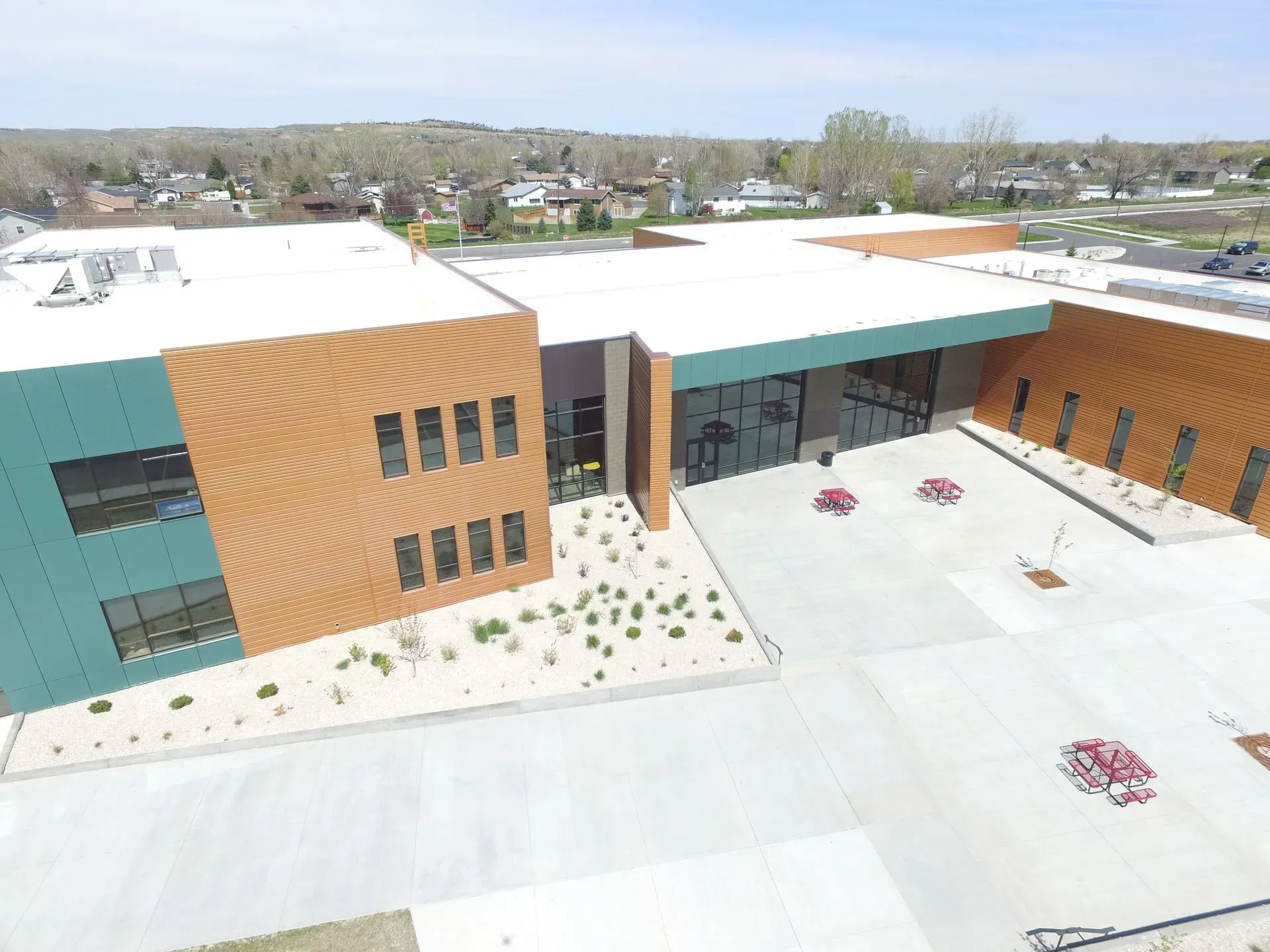An aerial view of a large building with a white roof.
