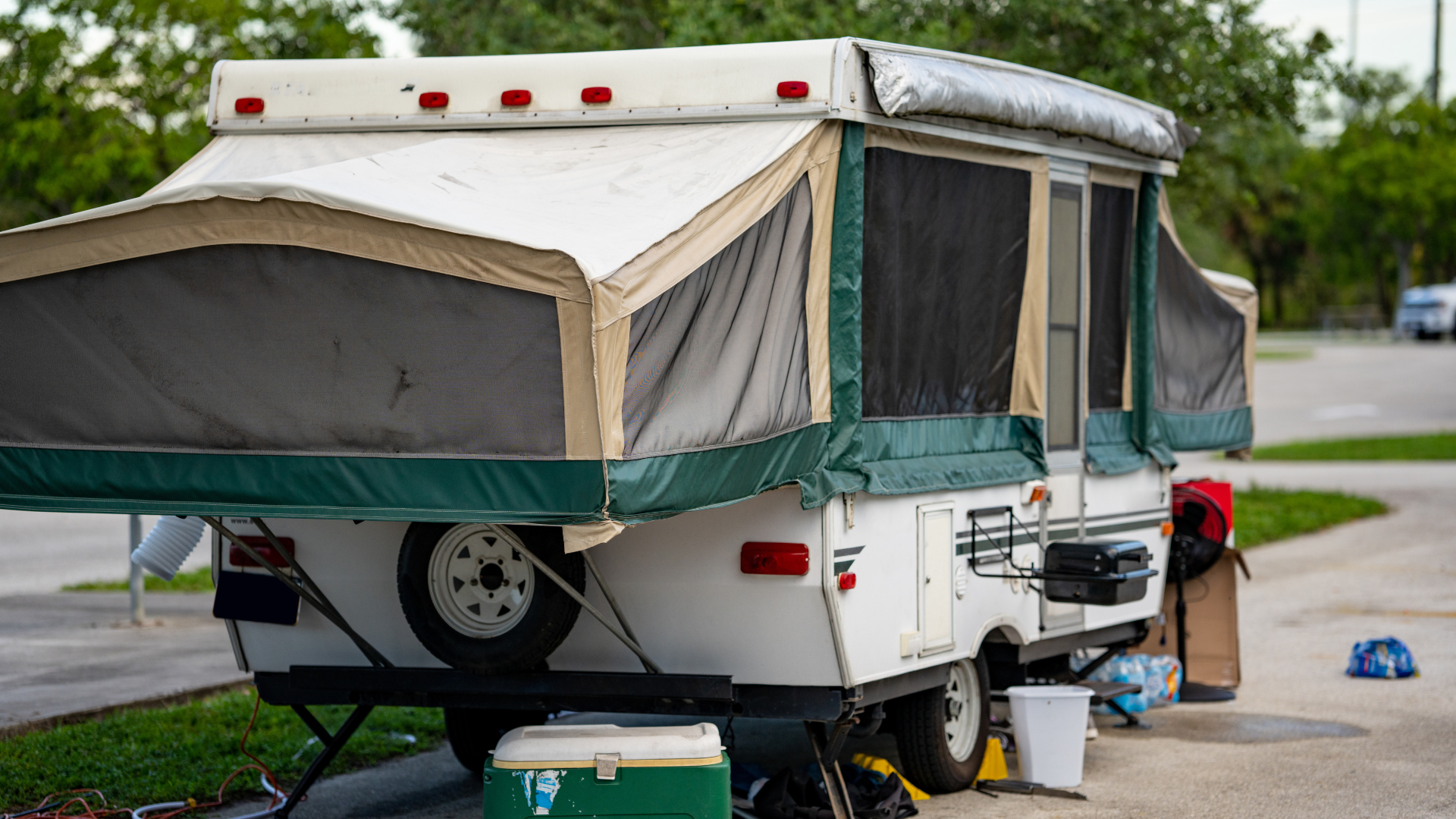 A pop up camper is parked on the side of the road.