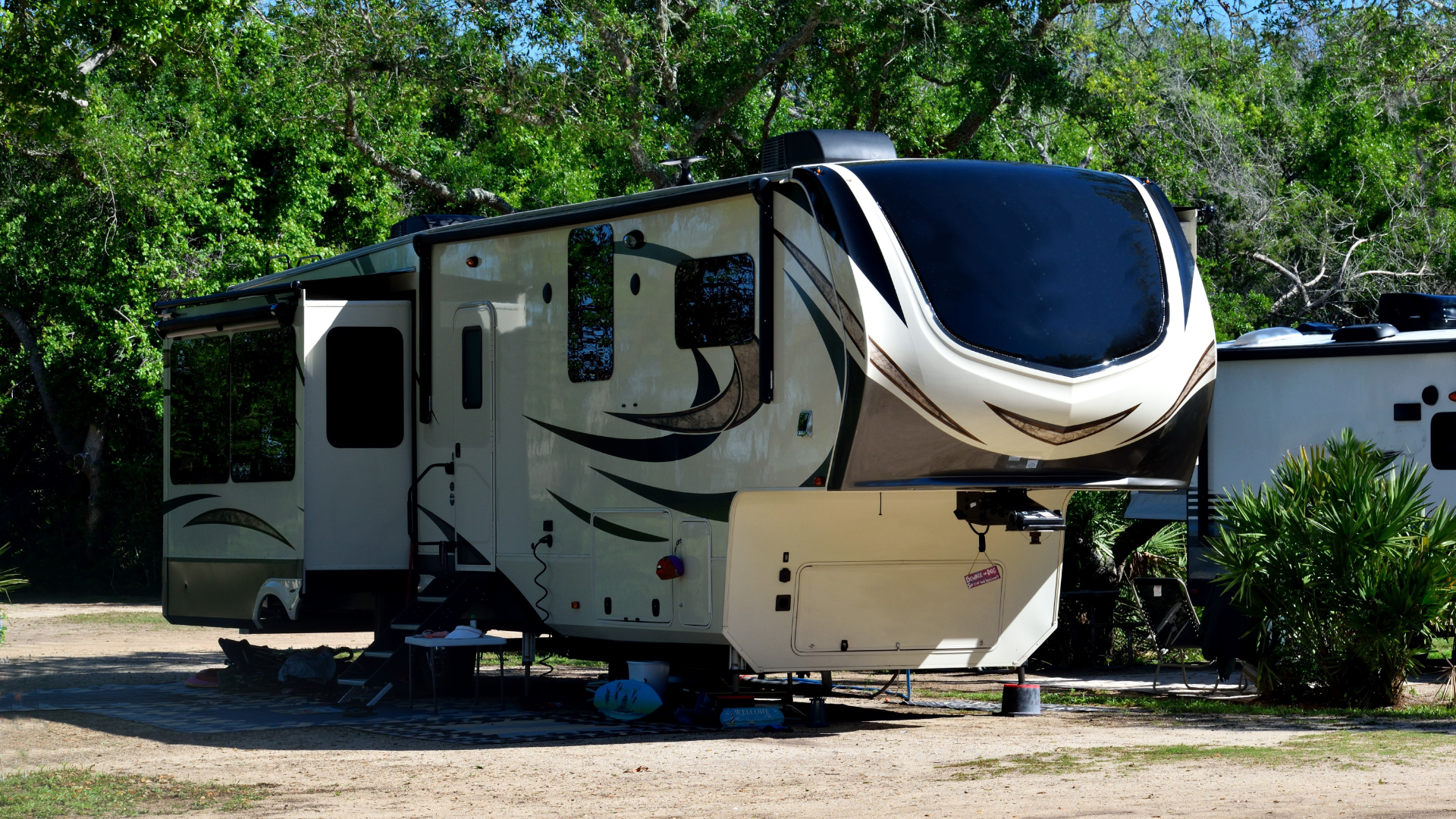 A white rv is parked in a gravel lot