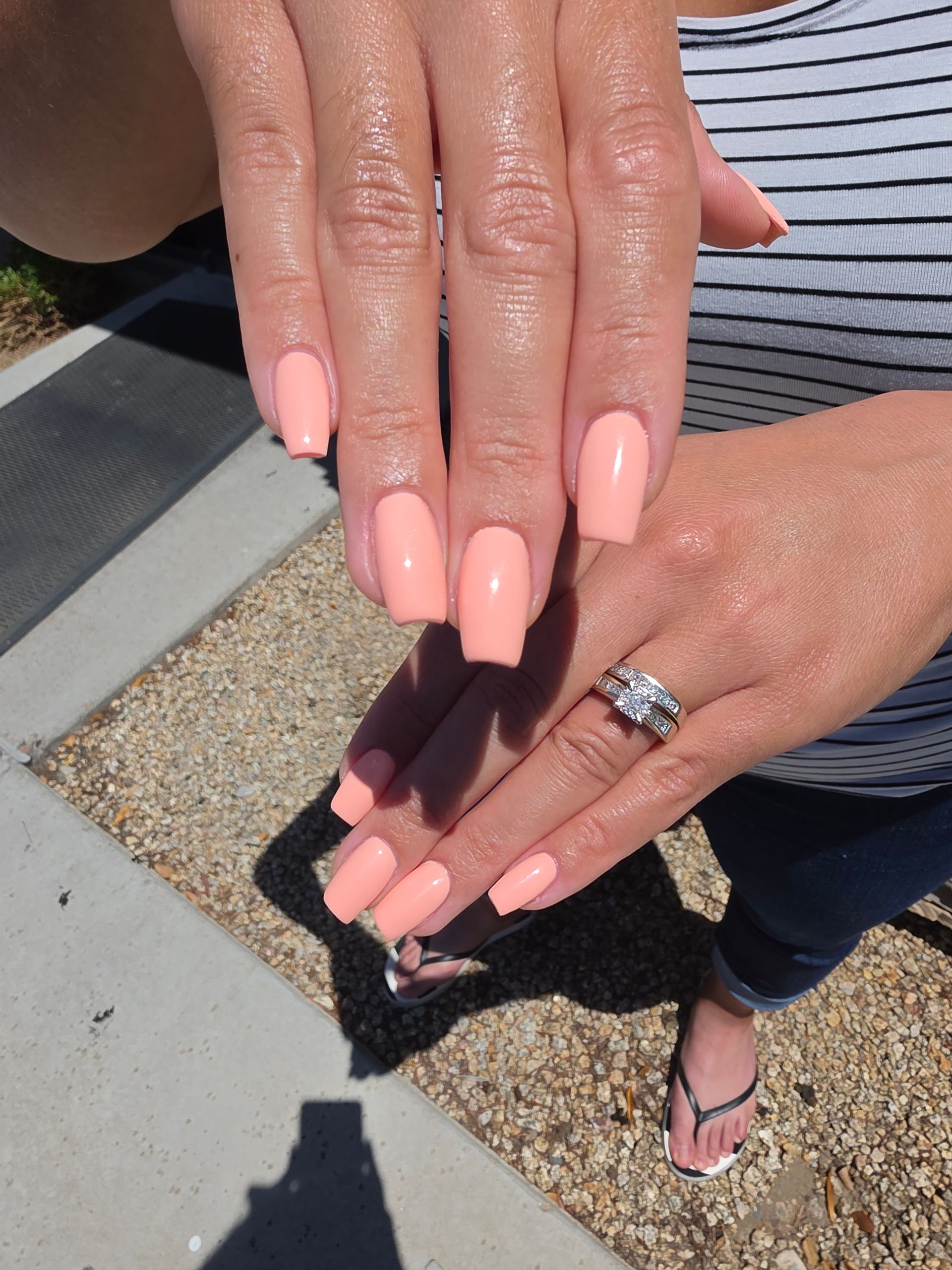 Hand with bright blue and nude nail art featuring black geometric accents on a gray towel