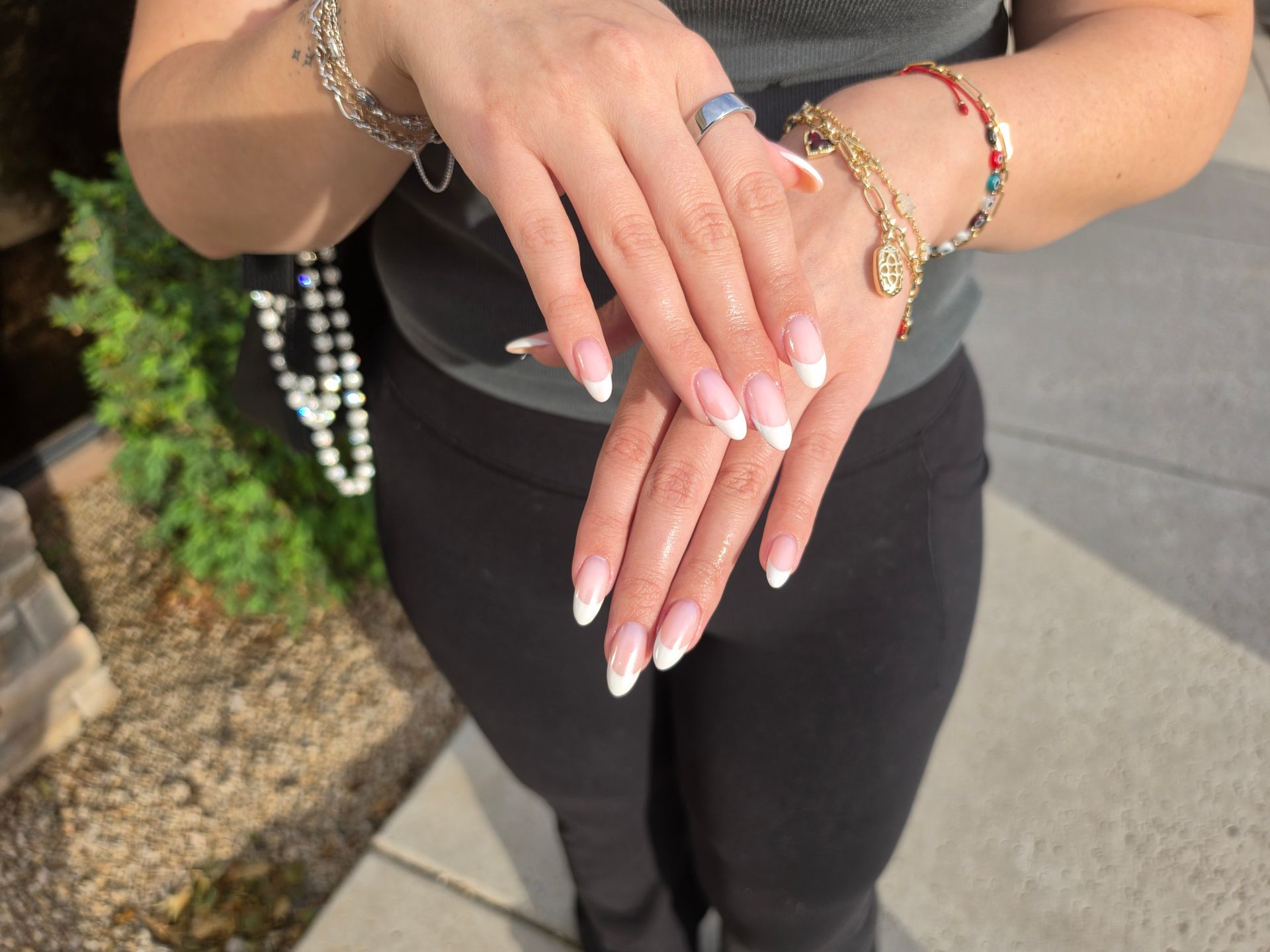 Close-up of hands with black and checkerboard nail art on a gray fabric background