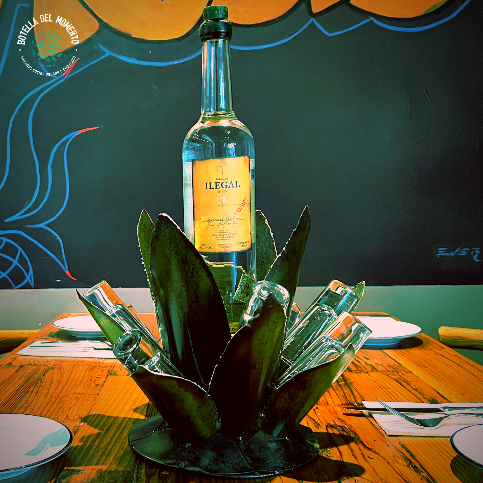 A bottle of tequila sits on a wooden table