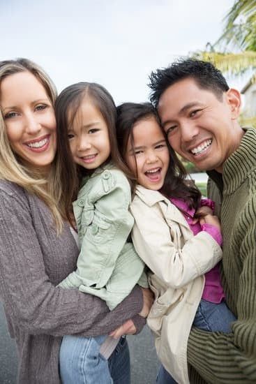 Smiling family hugging outdoors near palm trees
