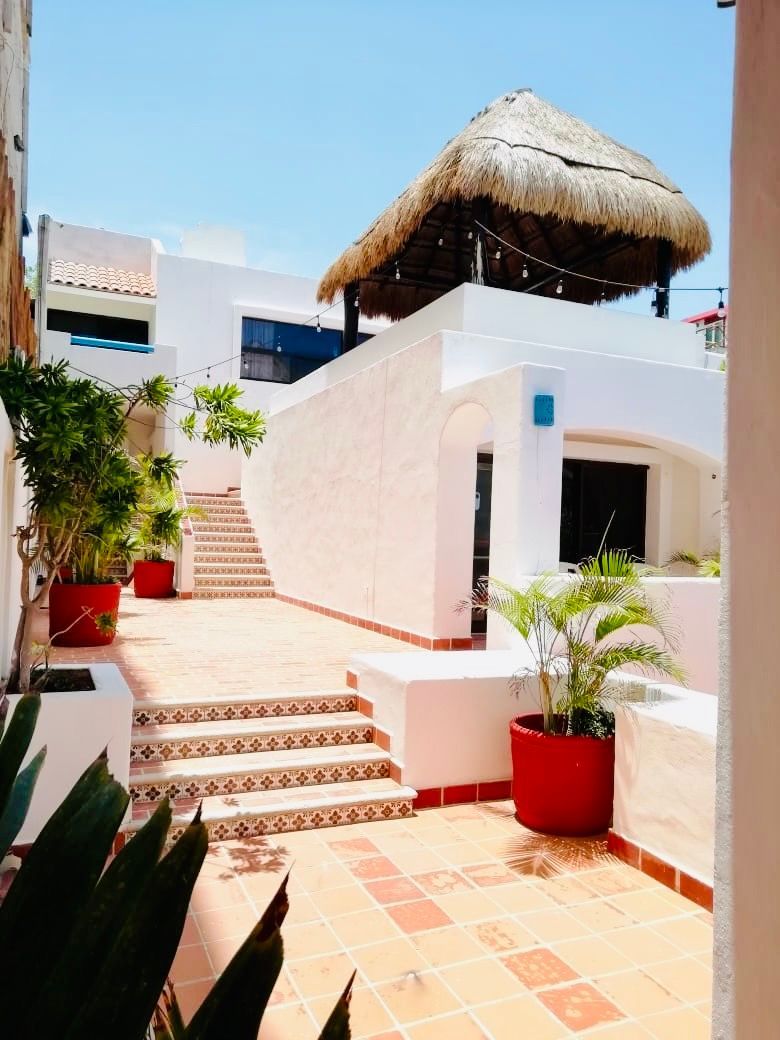 Un edificio blanco con techo de paja y escaleras.
