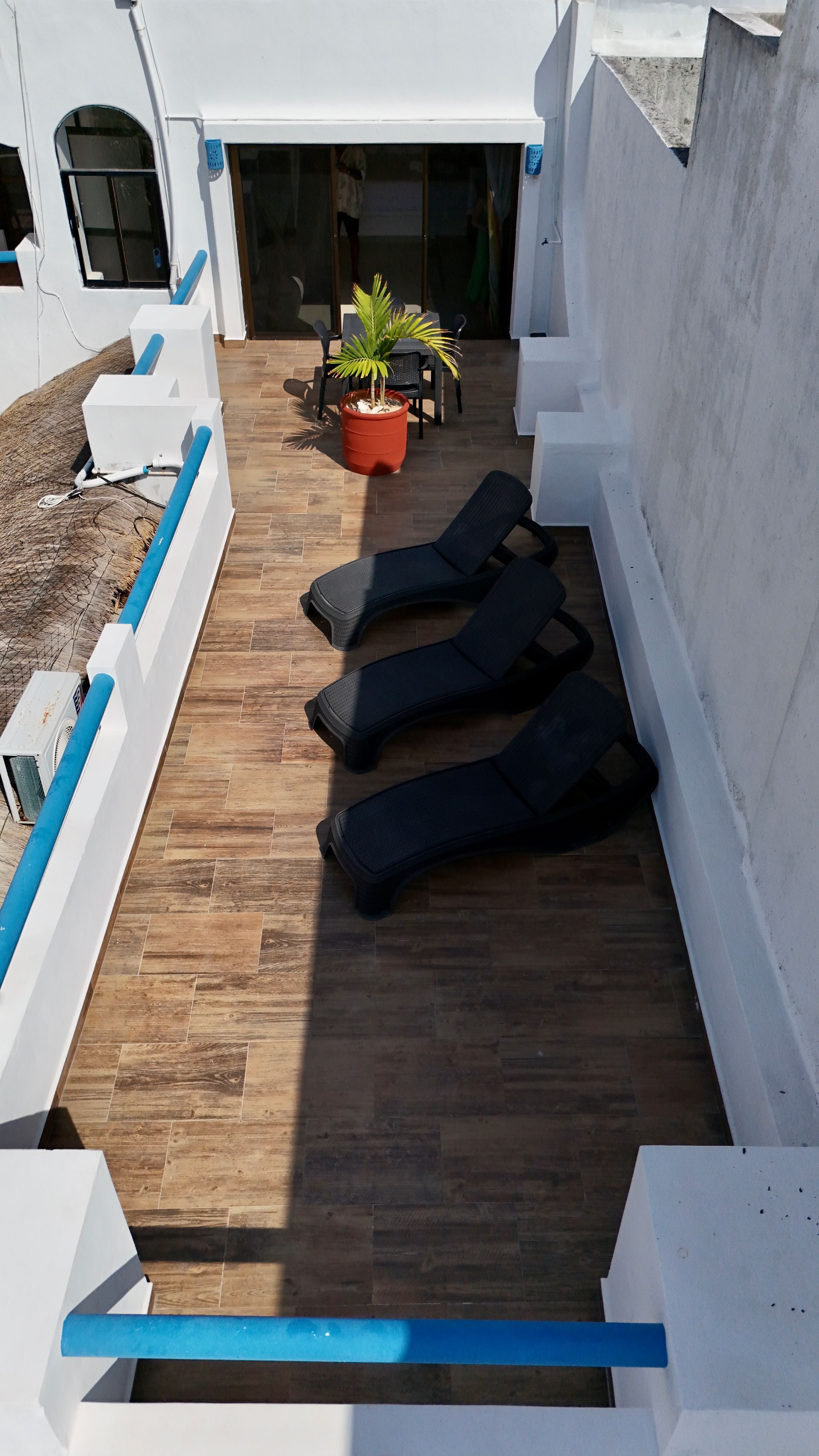 Una fila de sillones negros se encuentran sobre una terraza de madera.