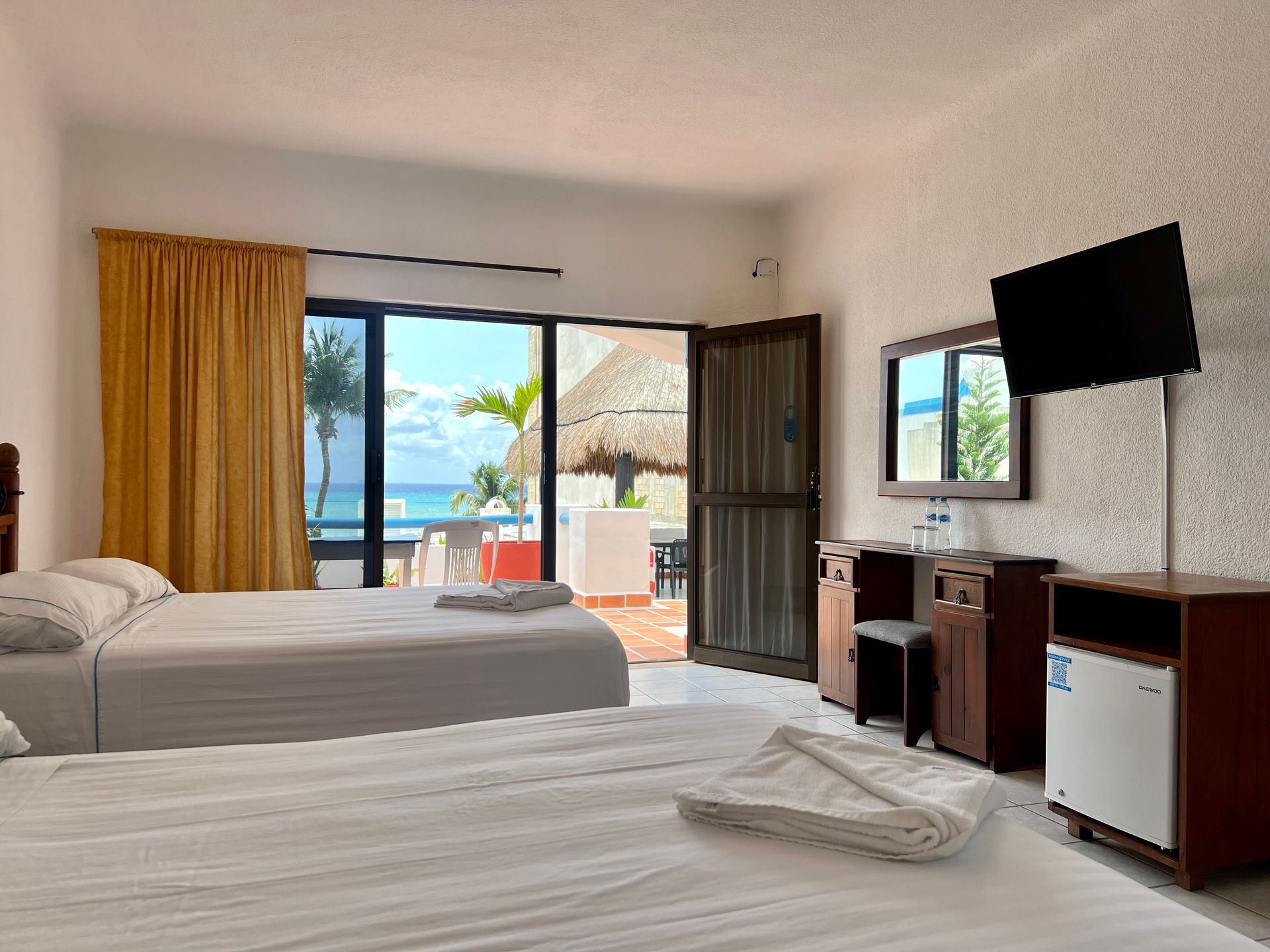 Una habitación de hotel con dos camas y un televisor de pantalla plana.