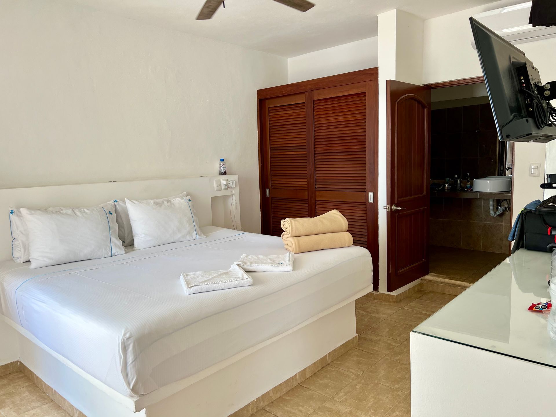 Una habitación de hotel con una cama tamaño king y un televisor de pantalla plana.
