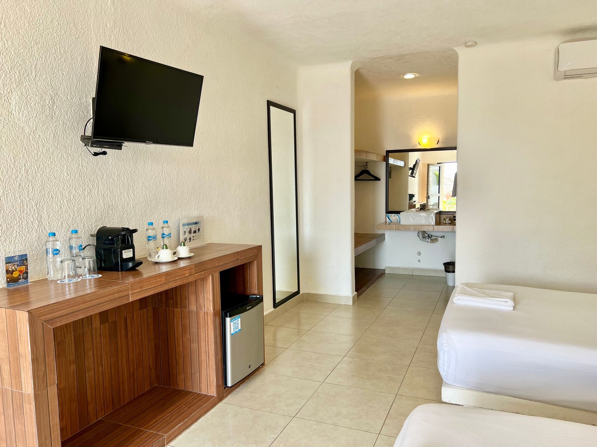 Una habitación de hotel con dos camas y un televisor de pantalla plana.
