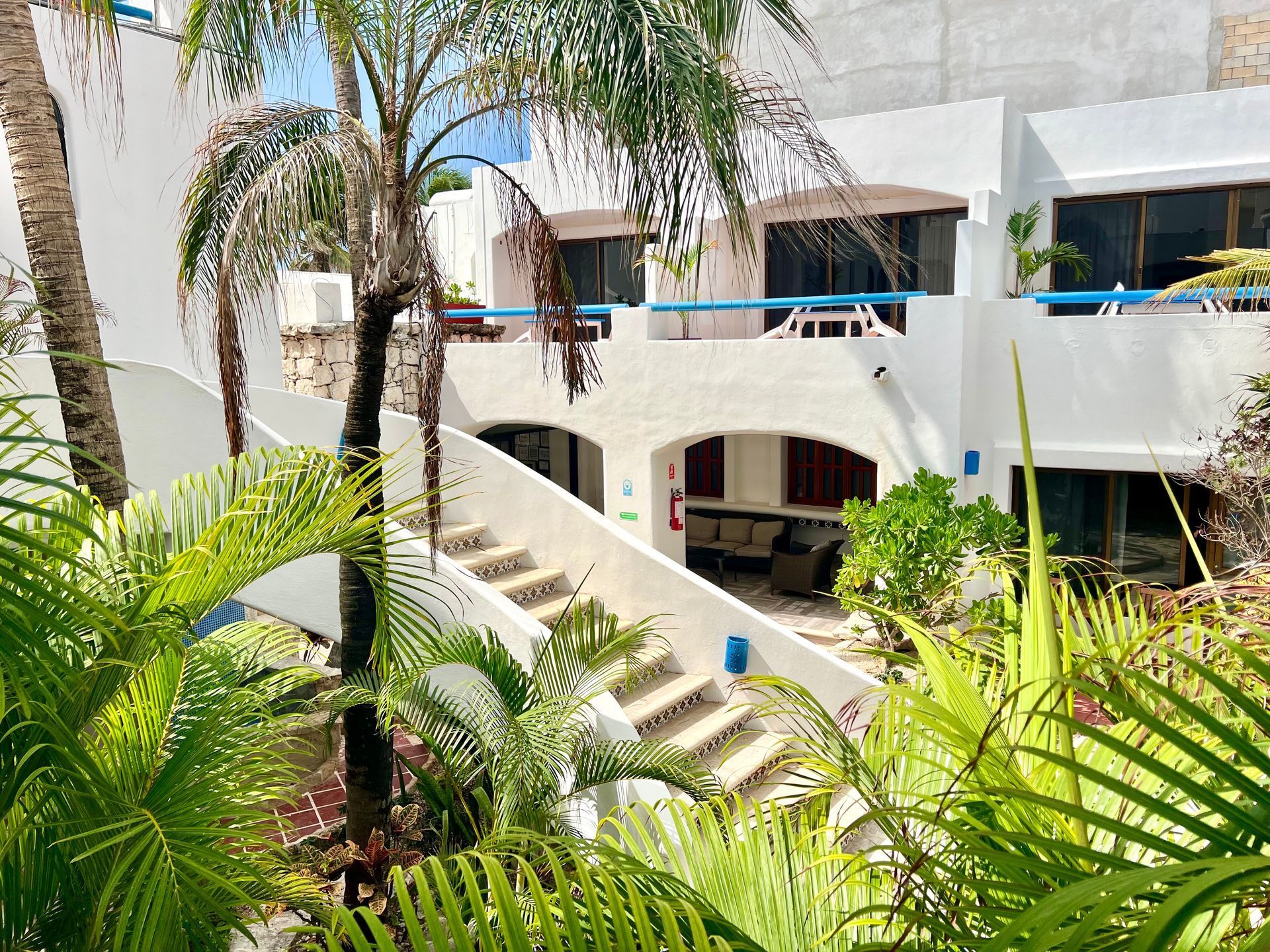 Un edificio blanco con palmeras delante.