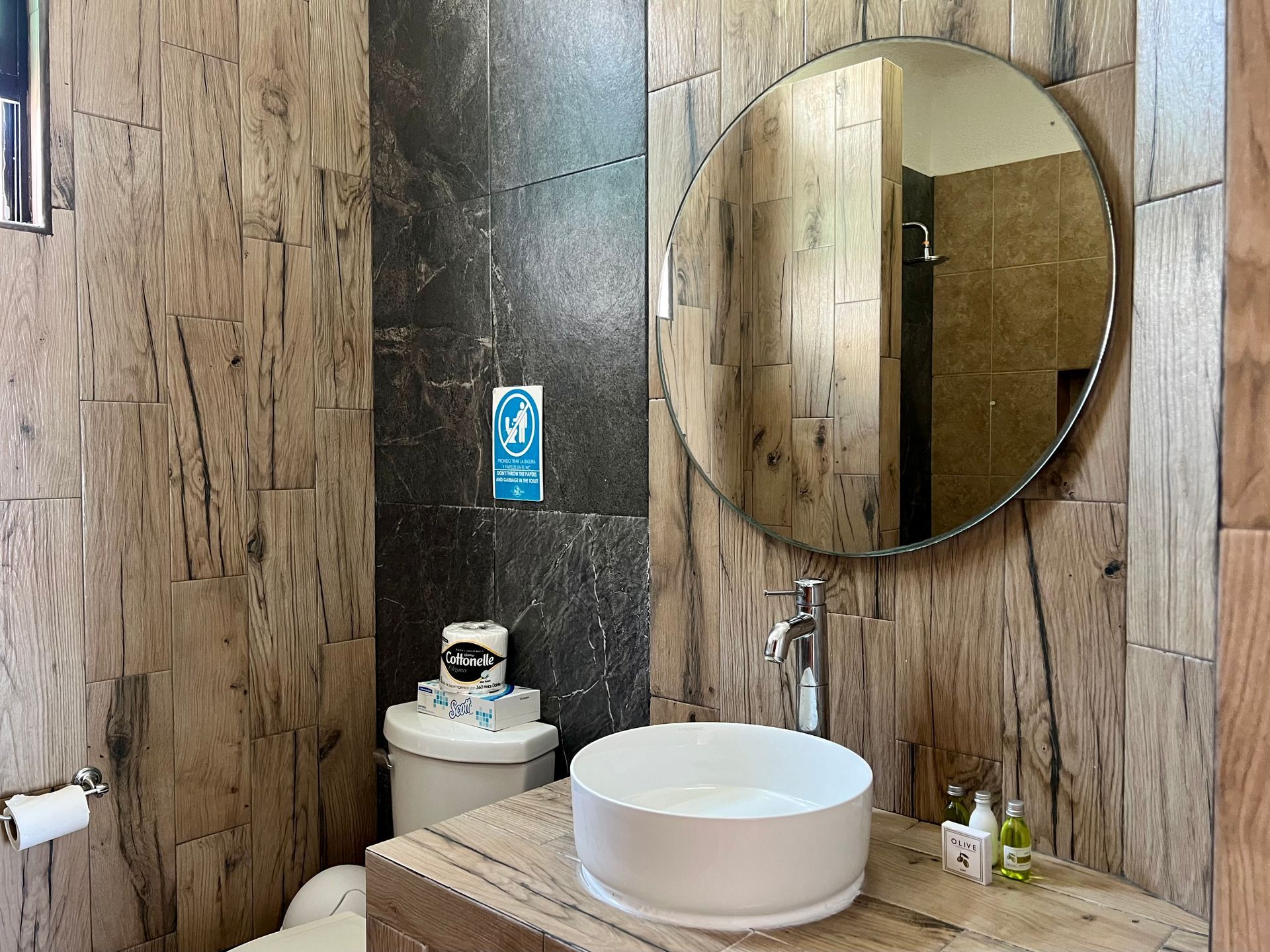 Un baño con inodoro, lavabo y espejo.