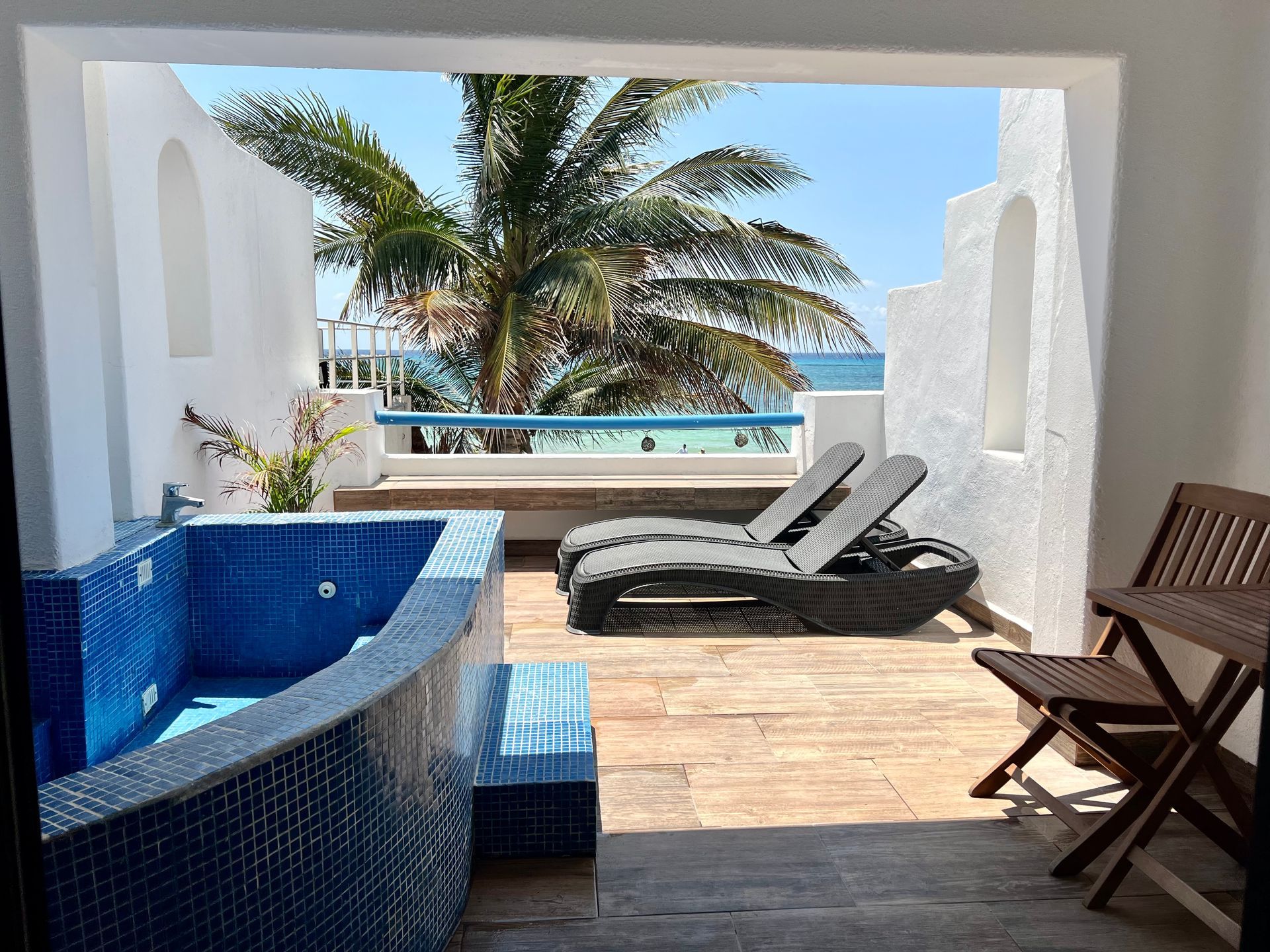 Hay un jacuzzi en el balcón con vista al mar.