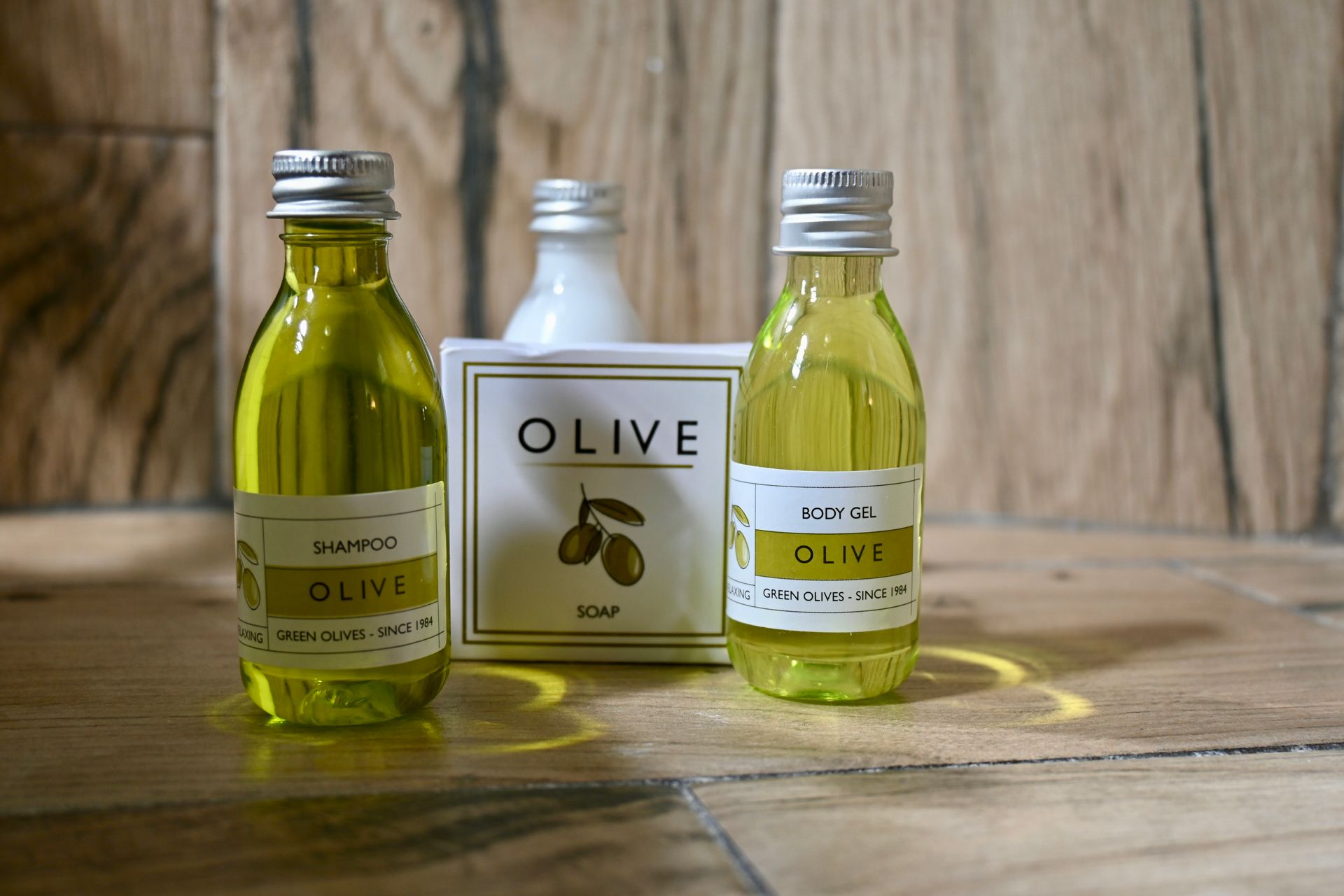 Dos botellas de aceite de oliva y una pastilla de jabón con una etiqueta