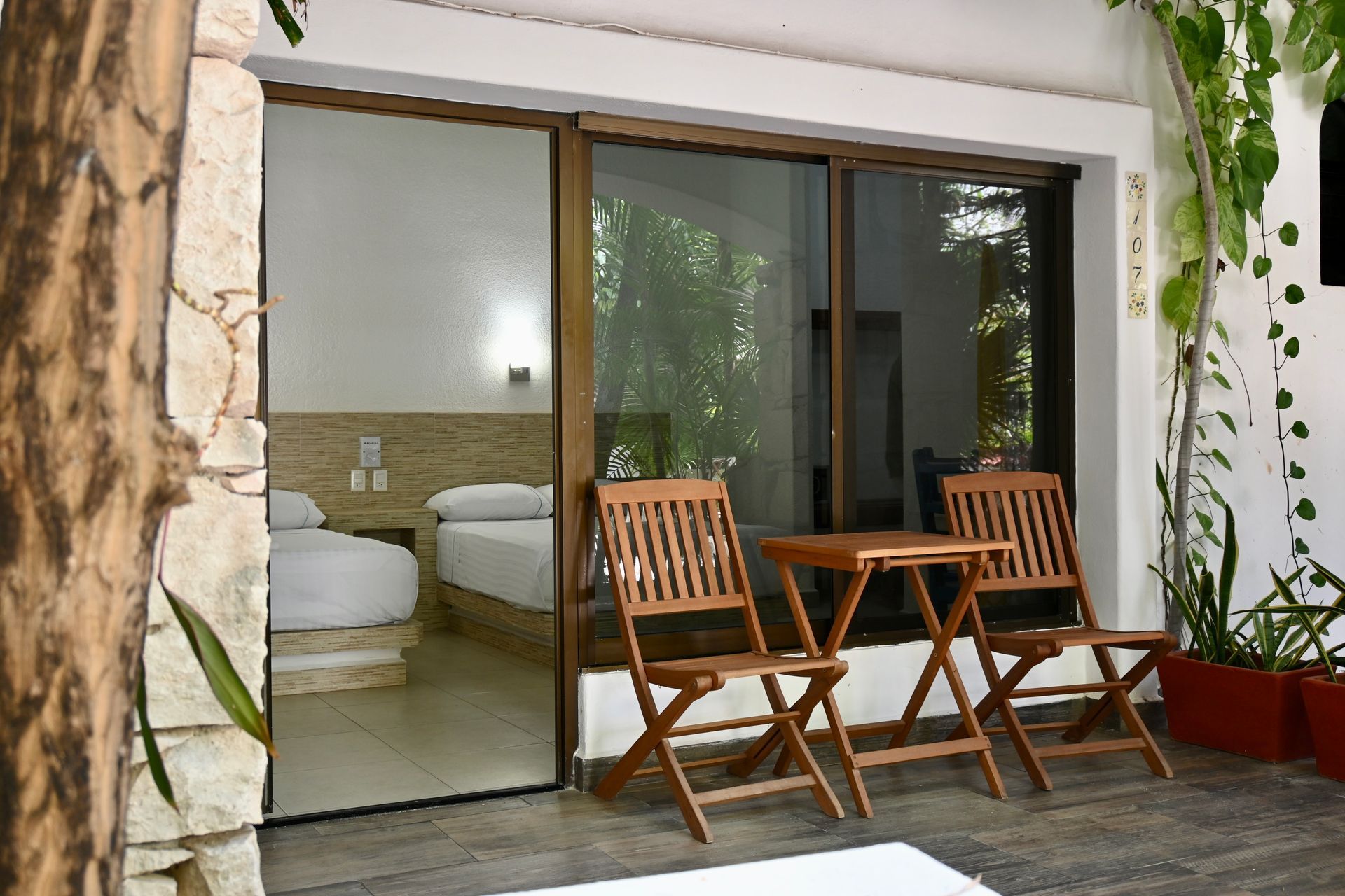 Una habitación con una puerta corrediza de vidrio y una mesa y sillas frente a ella.