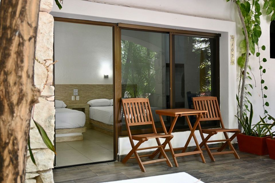 Una habitación con una puerta corrediza de vidrio y una mesa y sillas frente a ella.